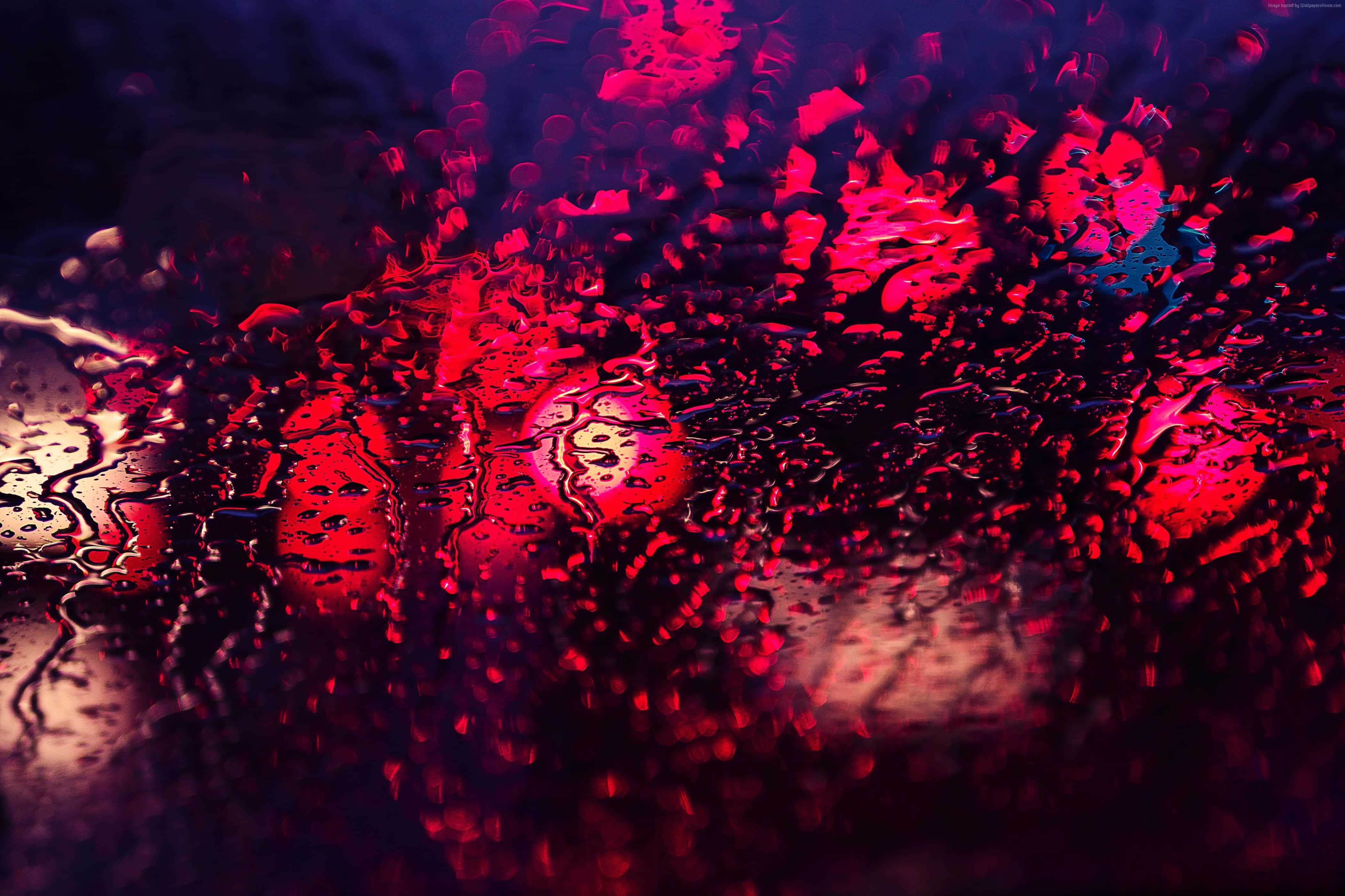 window 桌布 壁紙 — 鮮豔的紅色和藍色燈光透過被雨淋濕的玻璃變得模糊，營造出憂鬱的城市夜景。