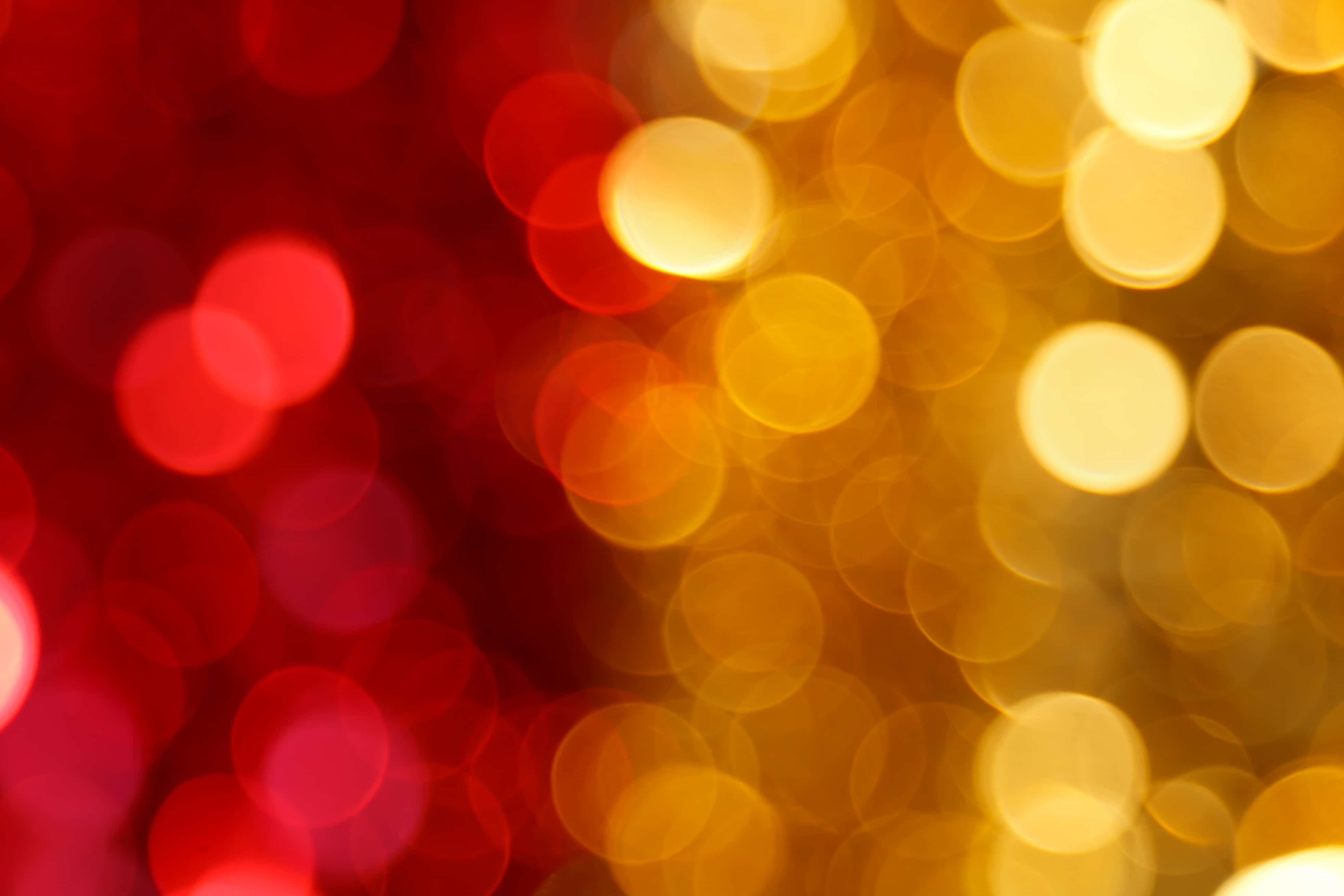 Bokeh 桌布 壁紙 — 鮮豔的紅色和金色散景燈光柔和地模糊成節日發光的背景。