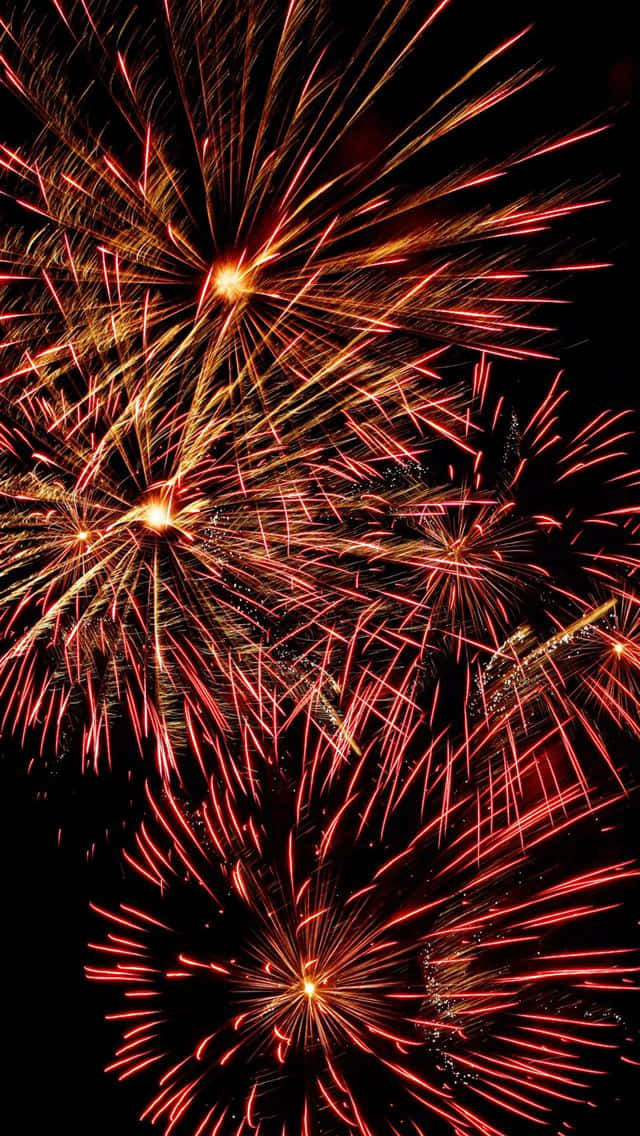 firework 桌布 壁紙 — 鮮豔的紅色和金色煙火在深邃的黑色夜空中綻放出耀眼的光芒。