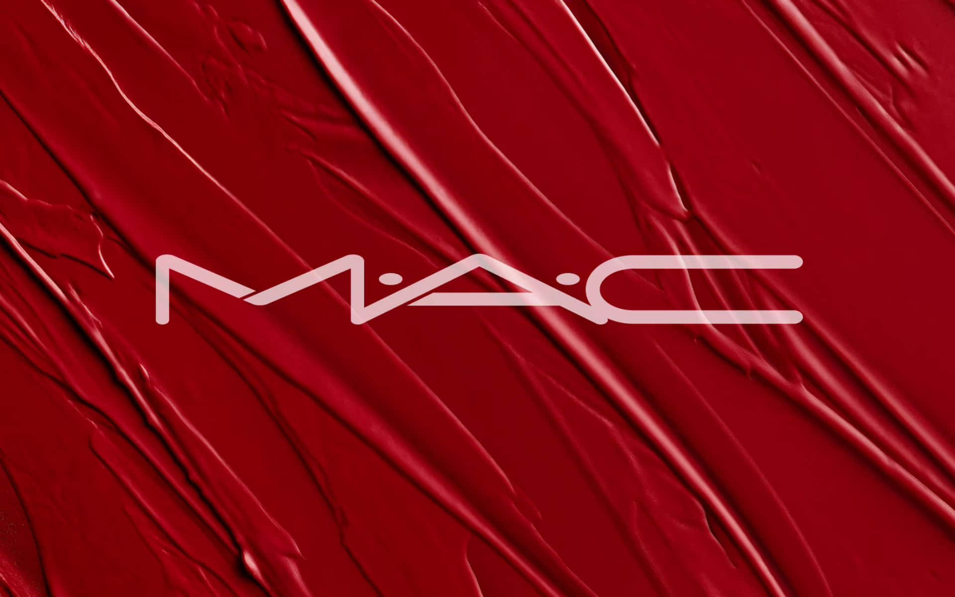 Mac Cosmetics 桌布 壁紙 — 鮮豔的紅色唇膏質地，帶有光澤的條紋，中央有白色MAC標誌。