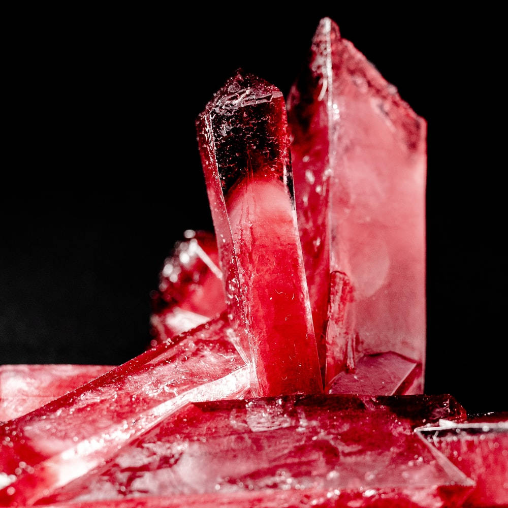 Red Crystal 桌布 壁紙 — 鮮豔的紅色水晶結構在純黑背景下閃爍著內在光芒。