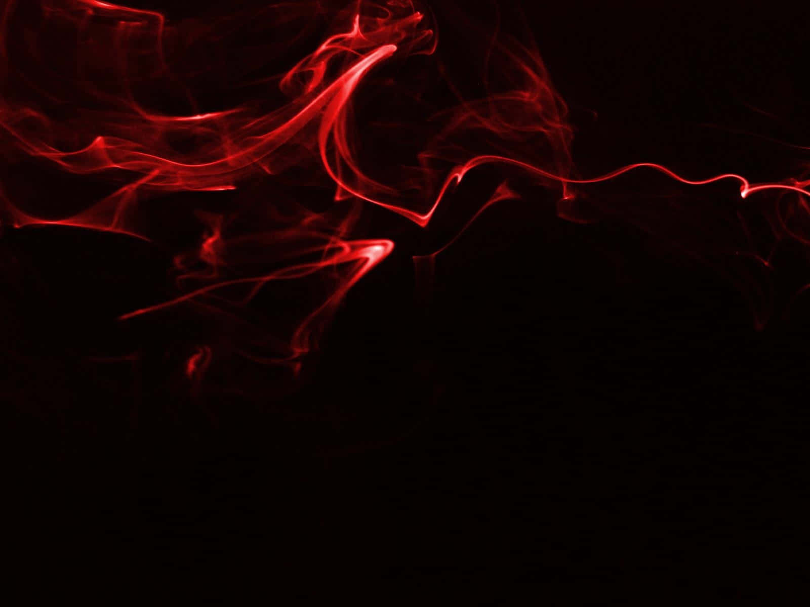 Black And Red 桌布 壁紙 — 鮮豔的紅色煙霧在深黑色背景上優雅地旋轉，營造出戲劇性的抽象構圖。