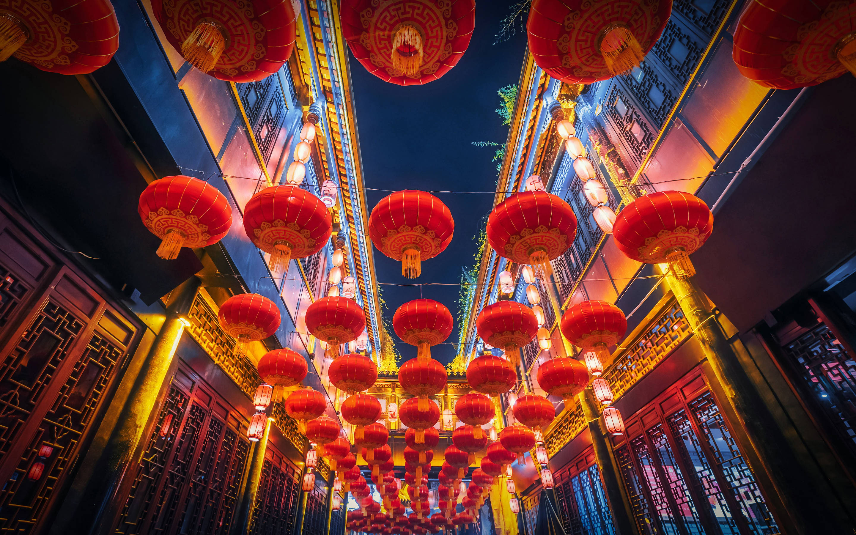 Chengdu 桌布 壁紙 — 鮮豔的紅色燈籠在傳統中式小巷中，對著深藍色的夜空溫暖地發光。