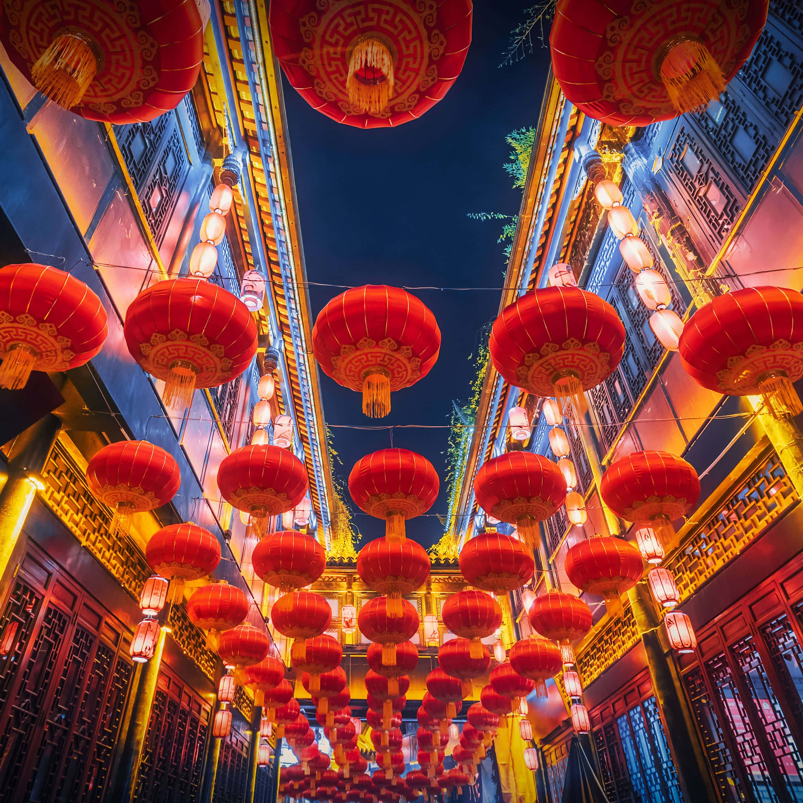 中文 桌布 壁紙 — 鮮豔的紅色燈籠在深藍色夜空下溫暖地發光，照亮傳統的中國小巷。