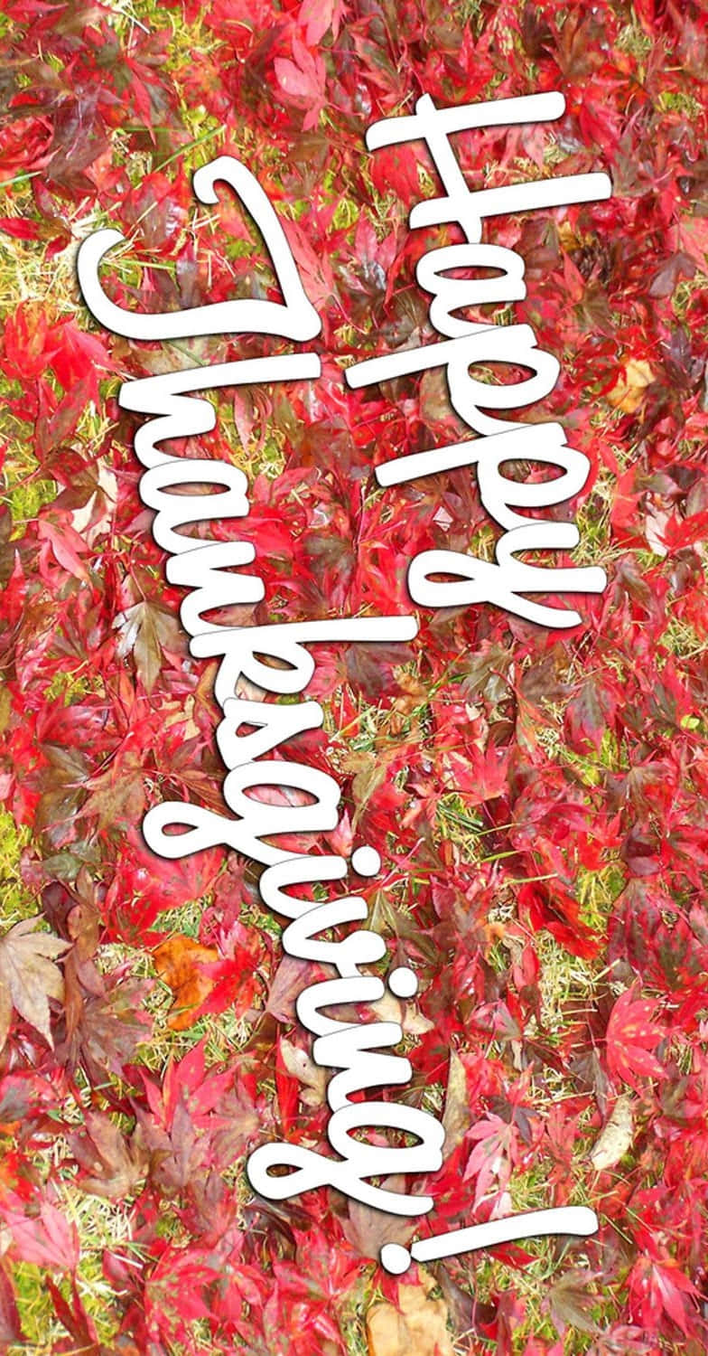 Thanksgiving Phone 桌布 壁紙 — 鮮豔的紅色秋葉形成有紋理的背景，上面有粗體白色草書文字寫著「Happy Thanksgiving!」
