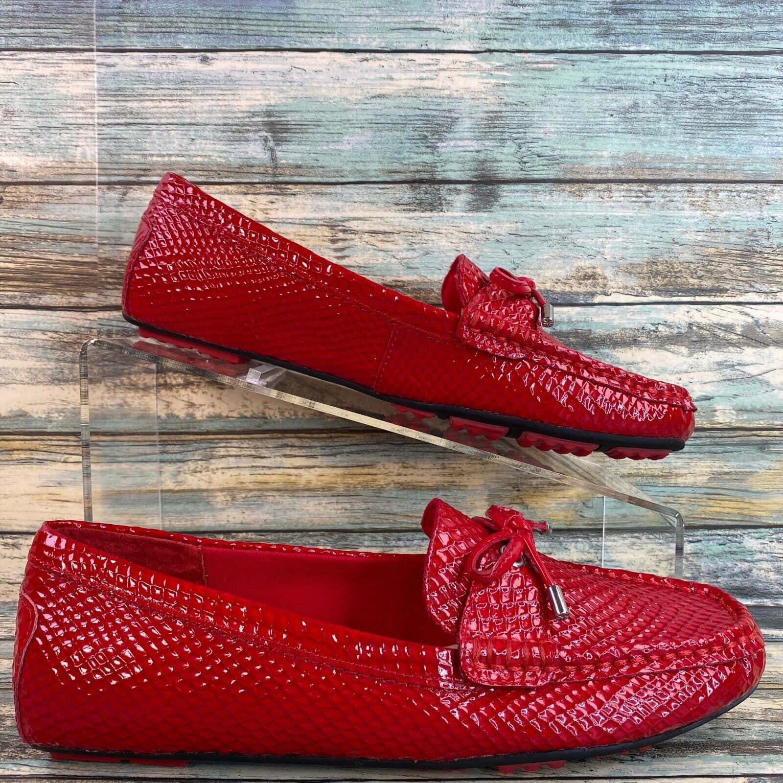 Red Shoes 桌布 壁紙 — 鮮豔的紅色蛇皮流蘇樂福鞋放置在風化的木質背景上，在明亮光線下閃閃發光。