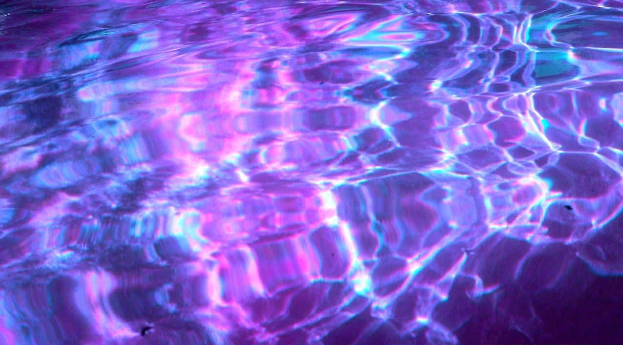 Purple Grunge Aesthetic 桌布 壁紙 — 鮮豔的紫色和藍色光波紋在平靜的水面上擴散，營造出迷人的霓虹光芒。