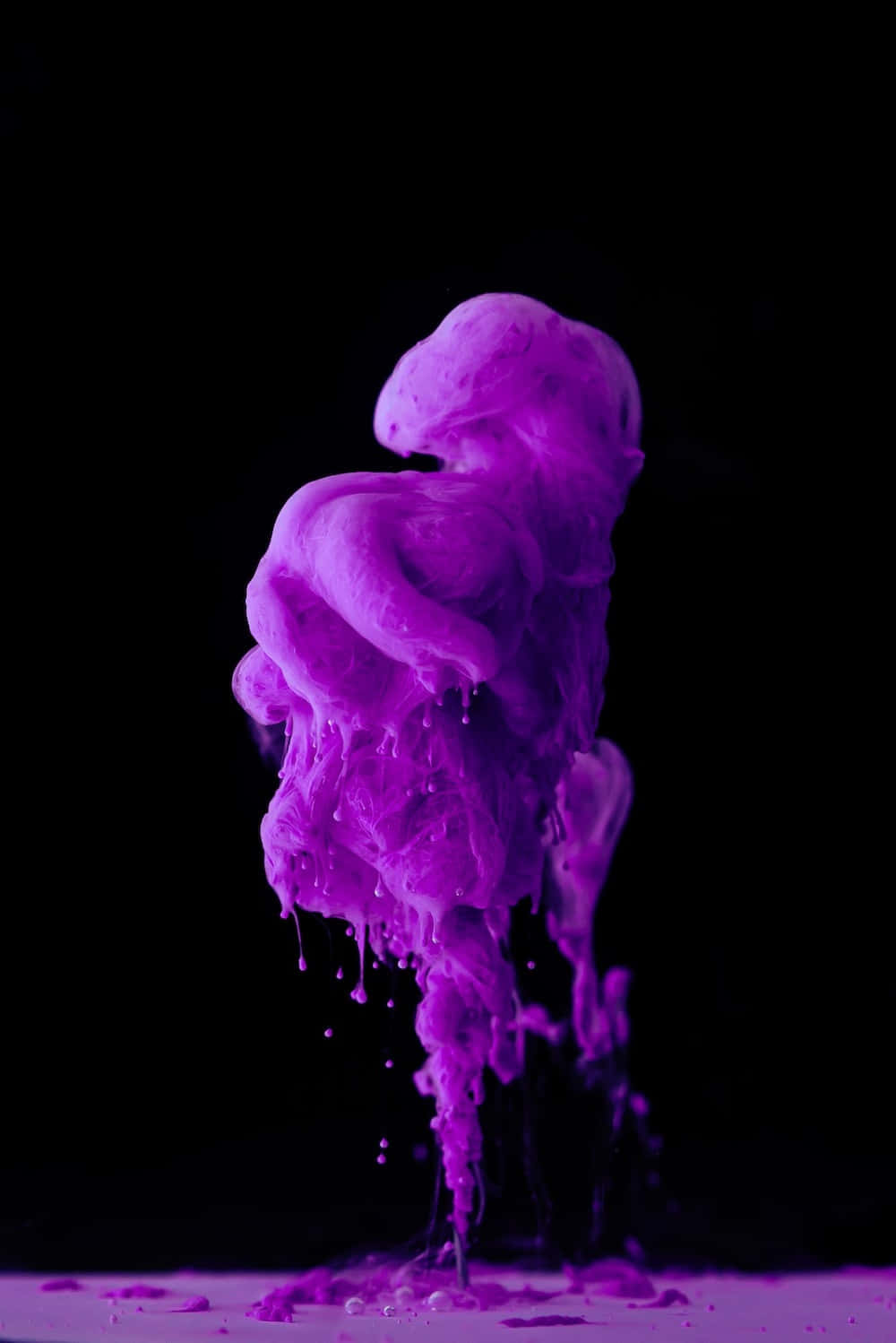 Purple Smoke 桌布 壁紙 — 鮮豔的紫色液體在漆黑的背景上如瀑布般傾瀉而下，並以戲劇性的慢動作捕捉滴落。