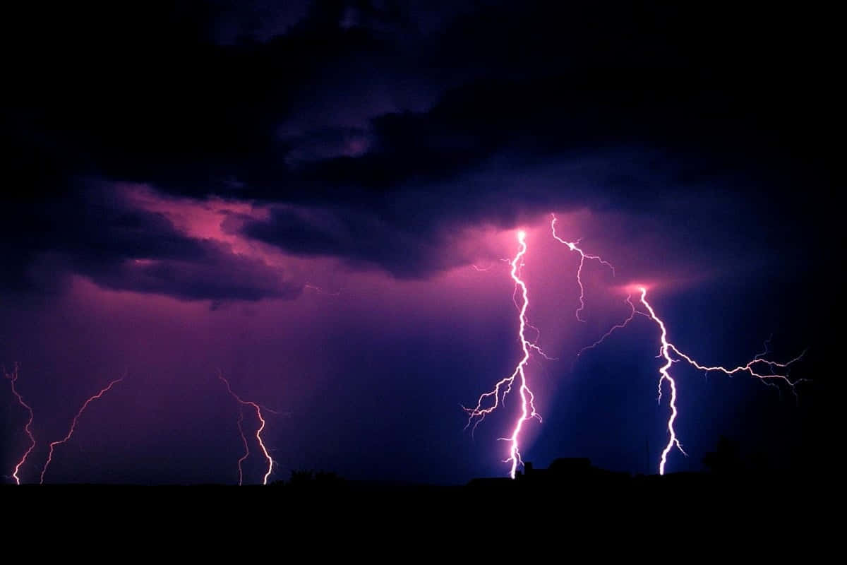 Thunderstorm 桌布 壁紙 — 鮮豔的紫色閃電在暴風雨的夜空中分叉，映襯著遠方山丘的黑暗輪廓。