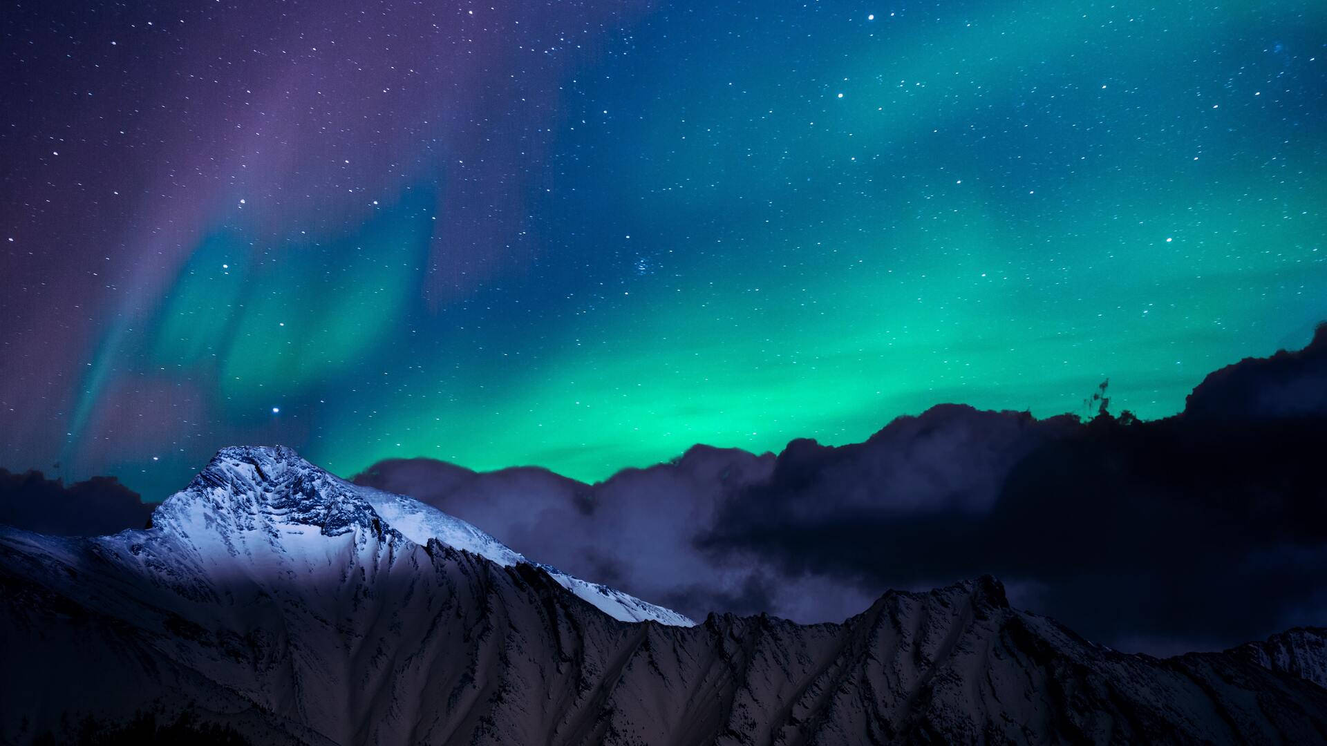 Beautiful Night 桌布 壁紙 — 鮮豔的綠色和紫色北極光在星空下在白雪覆蓋的山峰上舞動。
