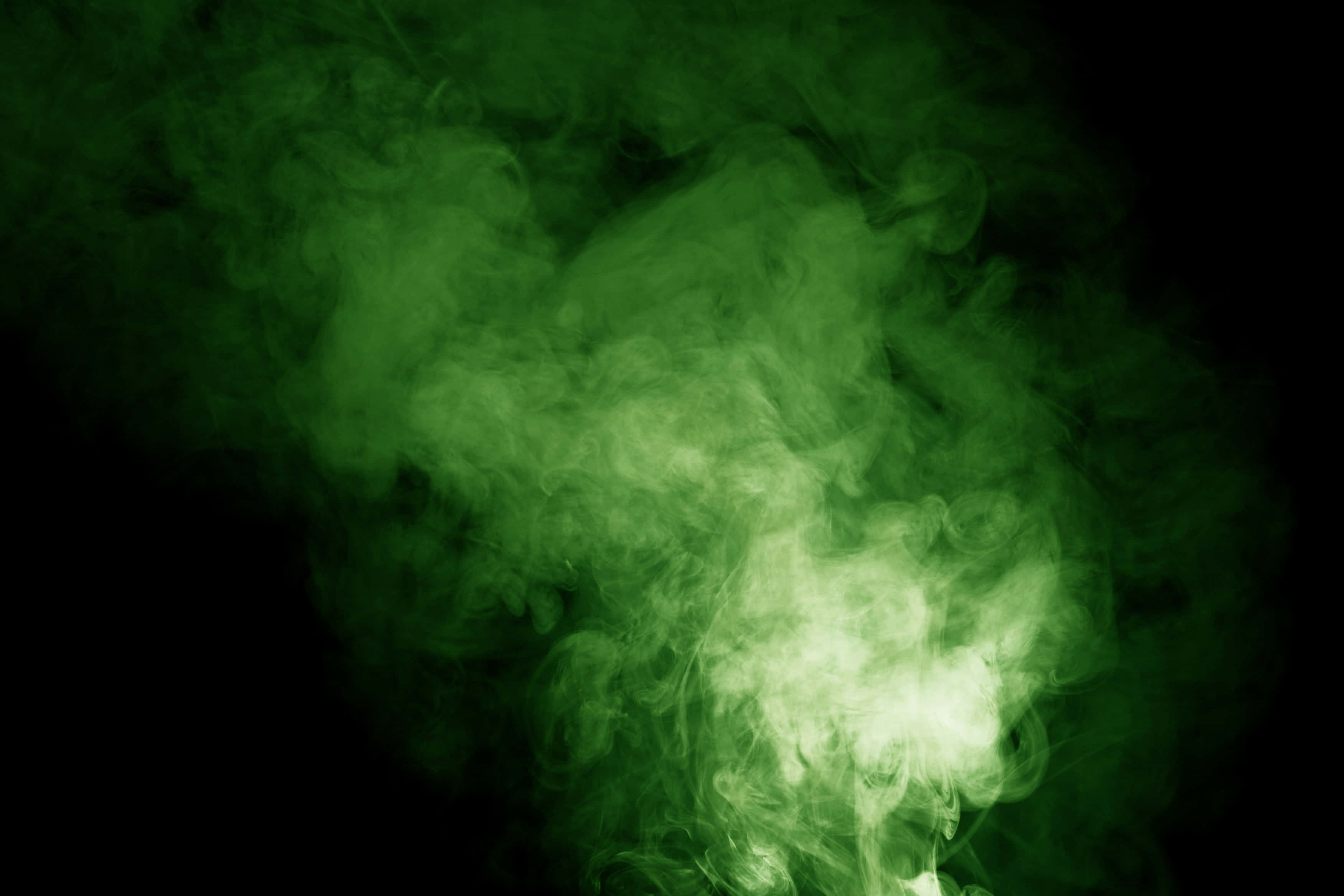Cool Green 桌布 壁紙 — 鮮豔的綠色煙霧在漆黑的背景中翻騰，帶有明亮的發光核心。