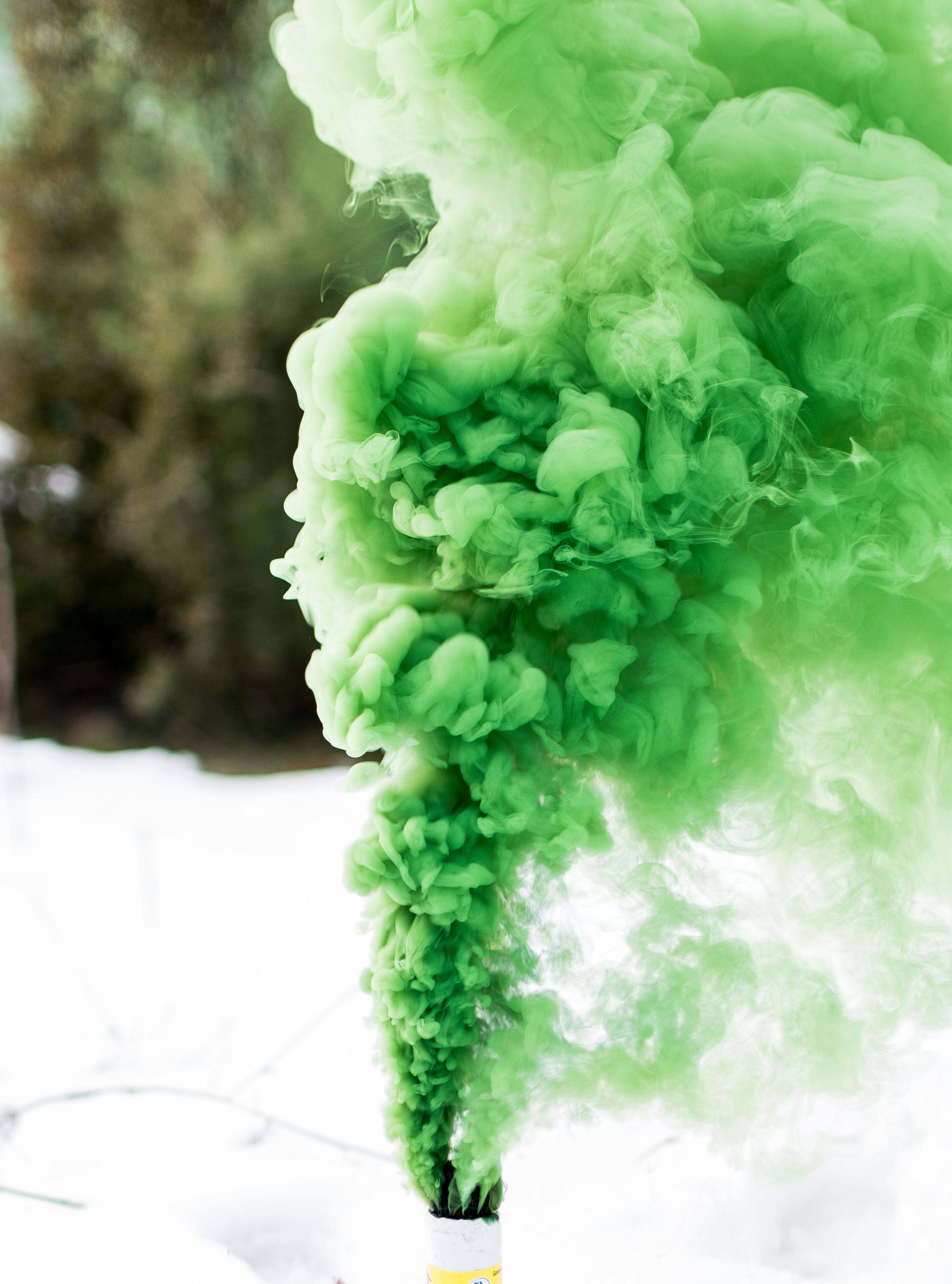 抽菸 桌布 壁紙 — 鮮豔的綠色煙霧在白雪皚皚的冬季背景和模糊的樹木中向上翻騰。