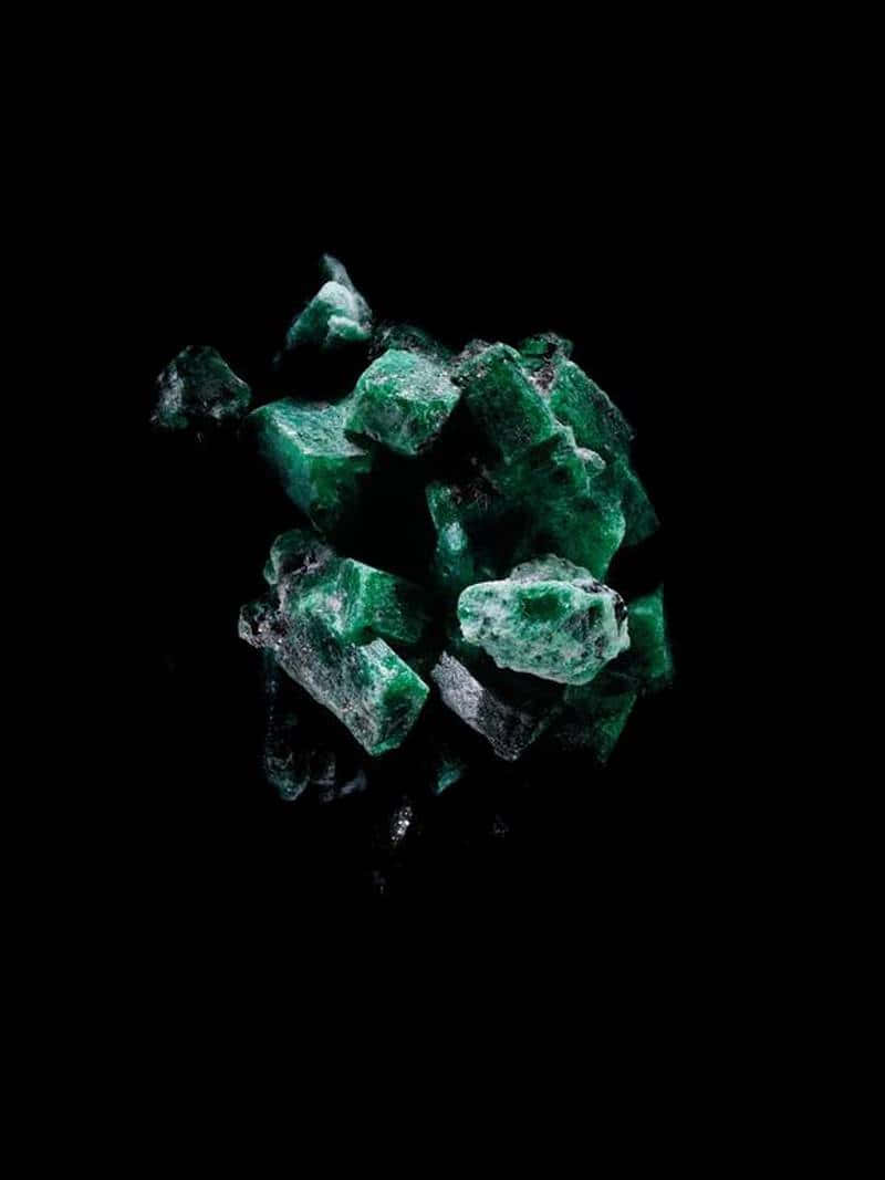 Emerald 桌布 壁紙 — 鮮豔的綠色祖母綠晶體簇擁在純黑背景上，散發著內在光芒和銳利的幾何切面。