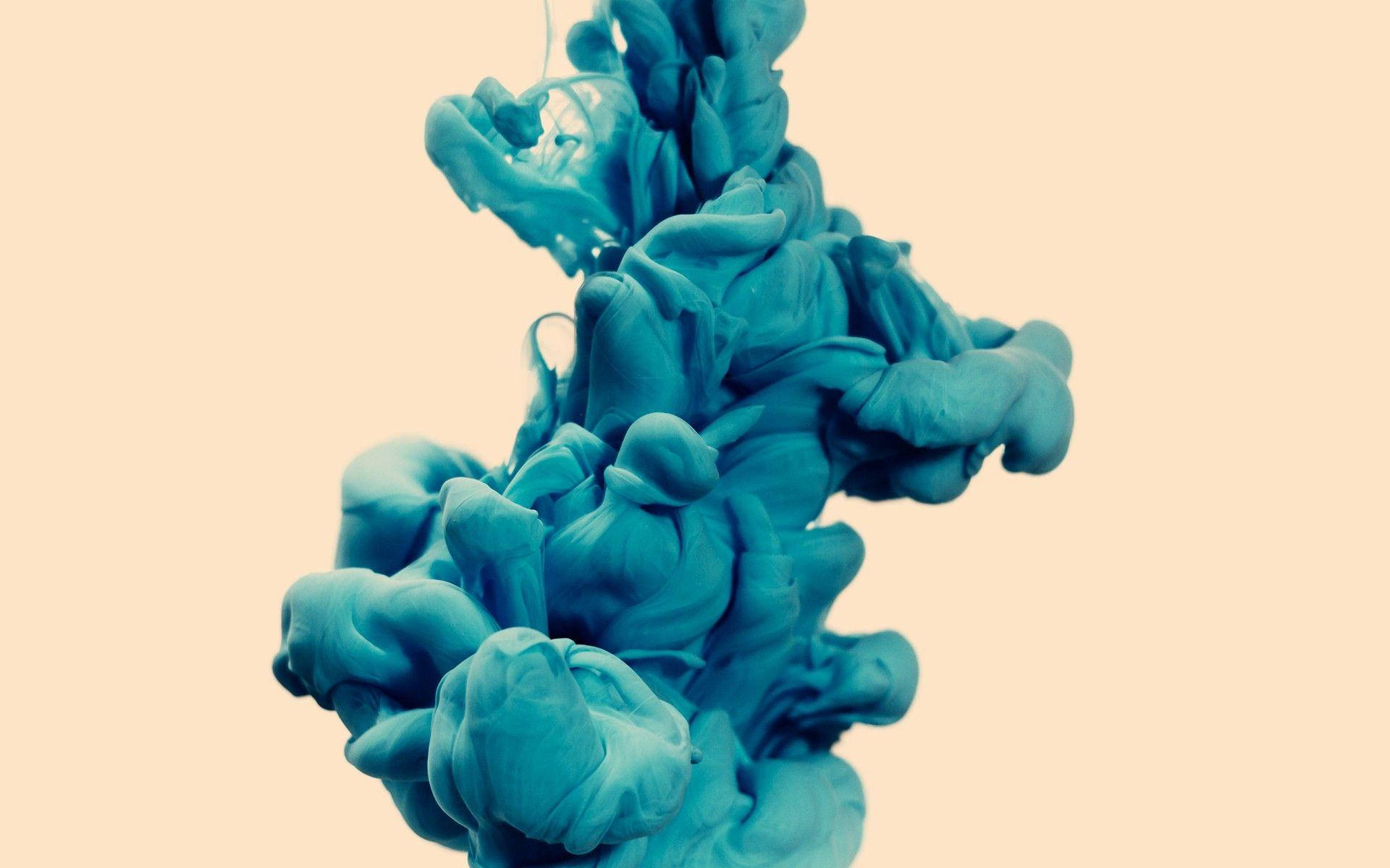 Cyan 桌布 壁紙 — 鮮豔的藍綠色墨水在柔和的蜜桃色背景上戲劇性地旋轉，形成迷人的抽象流體運動。