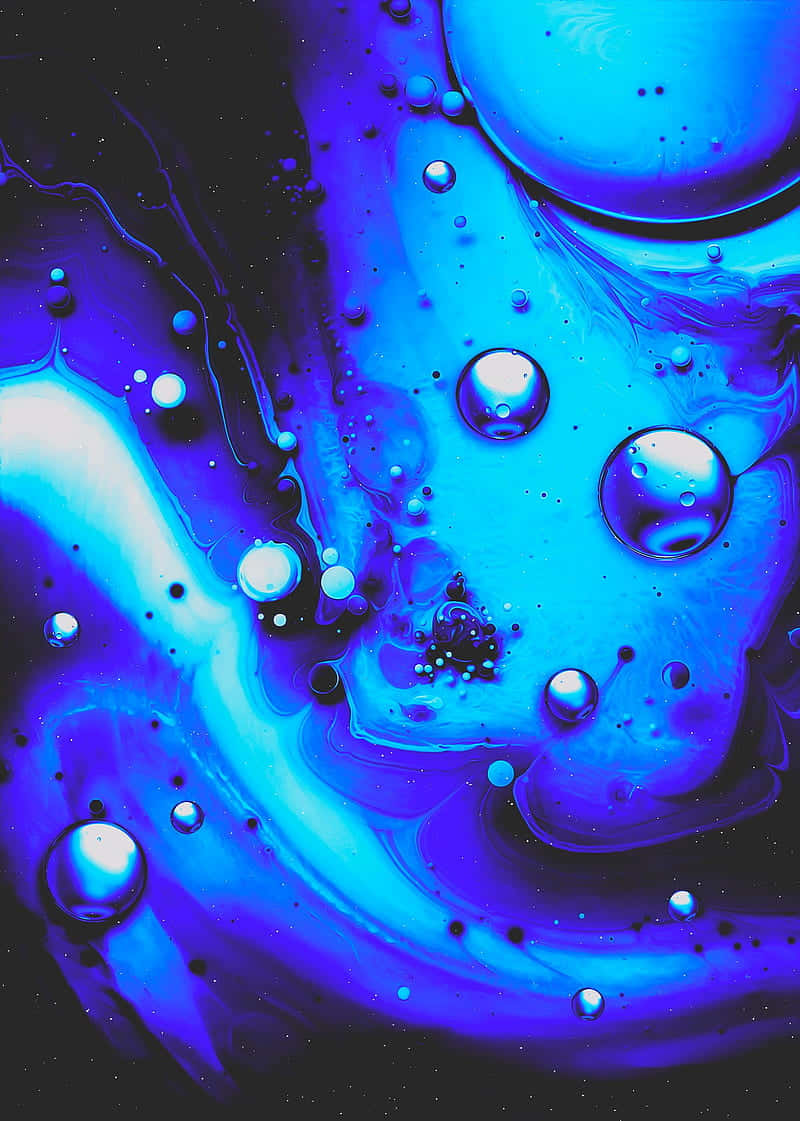 Trippy Blue 桌布 壁紙 — 鮮豔的藍色和紫色液體漩渦，帶有光澤氣泡，在深色背景上營造出宇宙抽象效果。