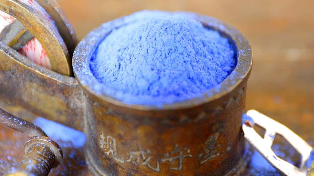 Powder Blue 桌布 壁紙 — 鮮豔的藍色粉末填滿了一個生鏽的金屬容器，旁邊是復古工具，放在磨損的木質表面上。