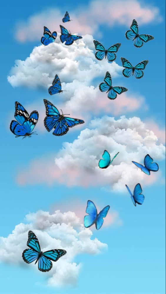 Cool Butterfly 桌布 壁紙 — 鮮豔的藍色蝴蝶在晴朗的天空下，於蓬鬆的白雲間優雅地飛舞。