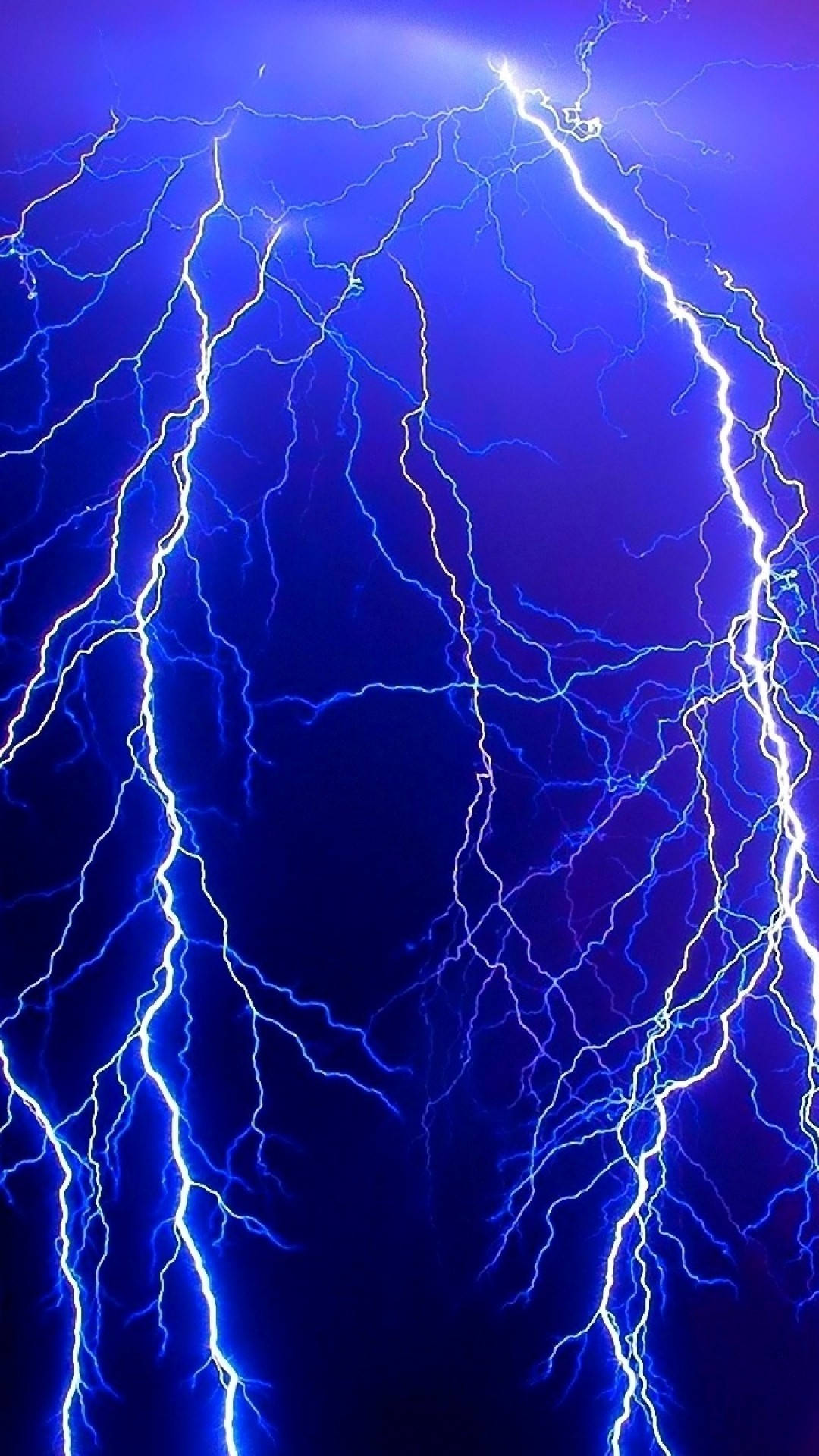 Weather 桌布 壁紙 — 鮮豔的藍色閃電在深靛藍色的天空中劈啪作響，呈現出戲劇性的自然風暴展示。