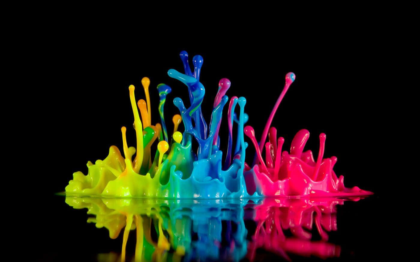 Paint Colour 桌布 壁紙 — 鮮豔的螢光顏料飛濺從反射表面噴出，背景為純黑色。