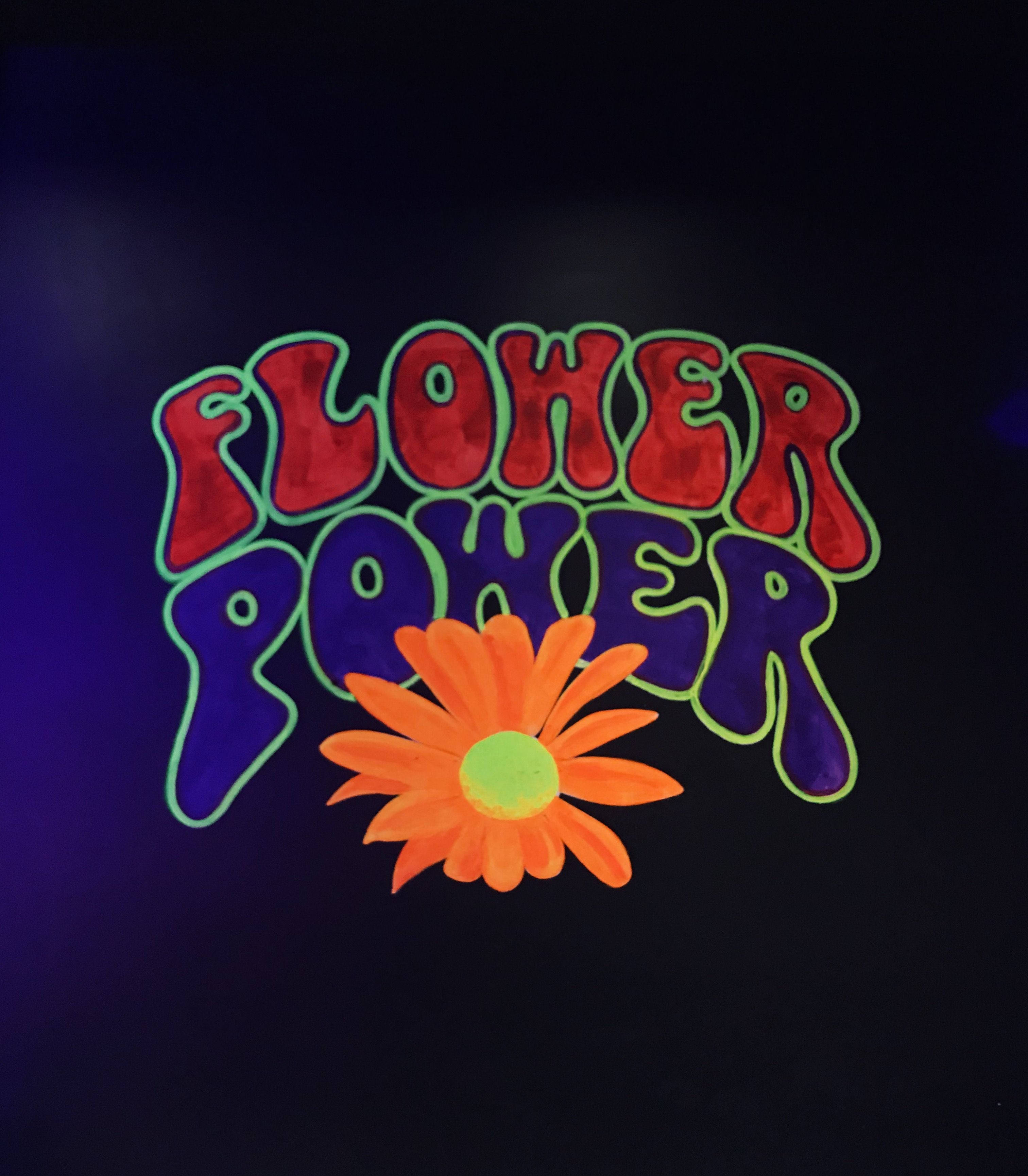 嬉皮 桌布 壁紙 — 鮮豔的霓虹燈 'Flower Power' 文字，帶有發光的橙色雛菊，背景為深紫色。