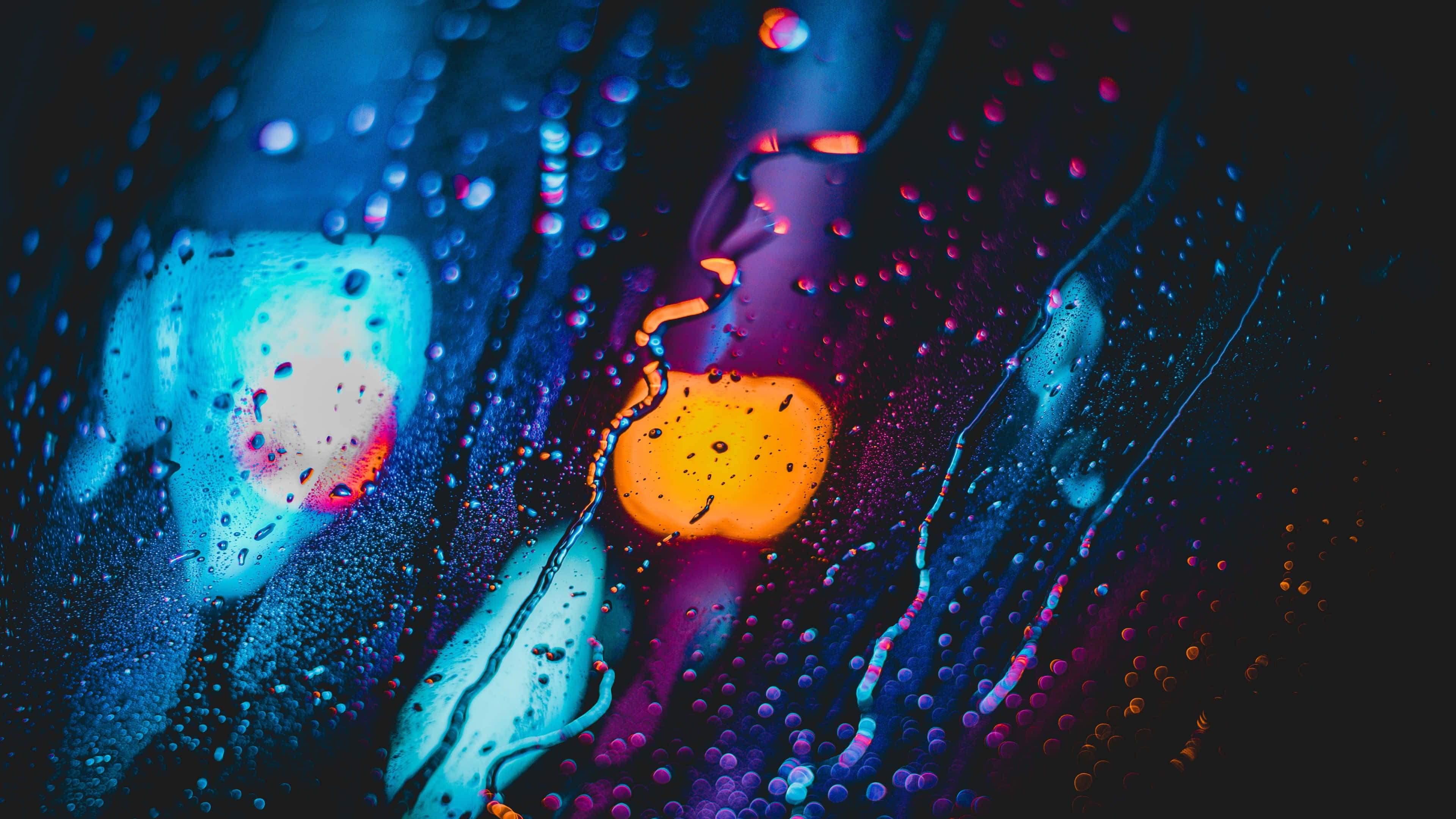 Rain 4K 桌布 壁紙 — 鮮豔的霓虹燈光透過被雨水打濕的玻璃反射，營造出帶有電光藍、紫色和溫暖橙色的夢幻抽象光芒。