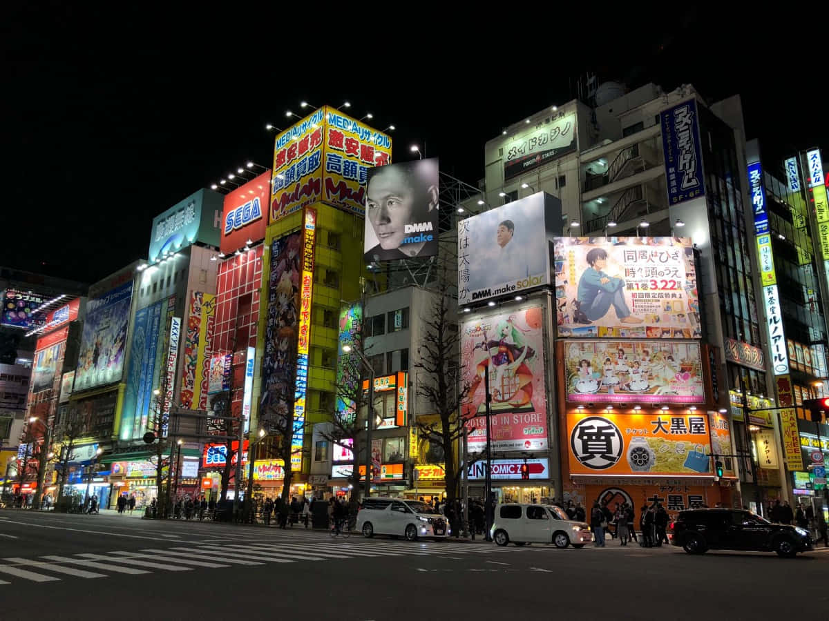 Otaku Culture 桌布 壁紙 — 鮮豔的霓虹燈招牌照亮了東京夜晚繁忙的街道，人群熙攘，廣告牌閃爍。