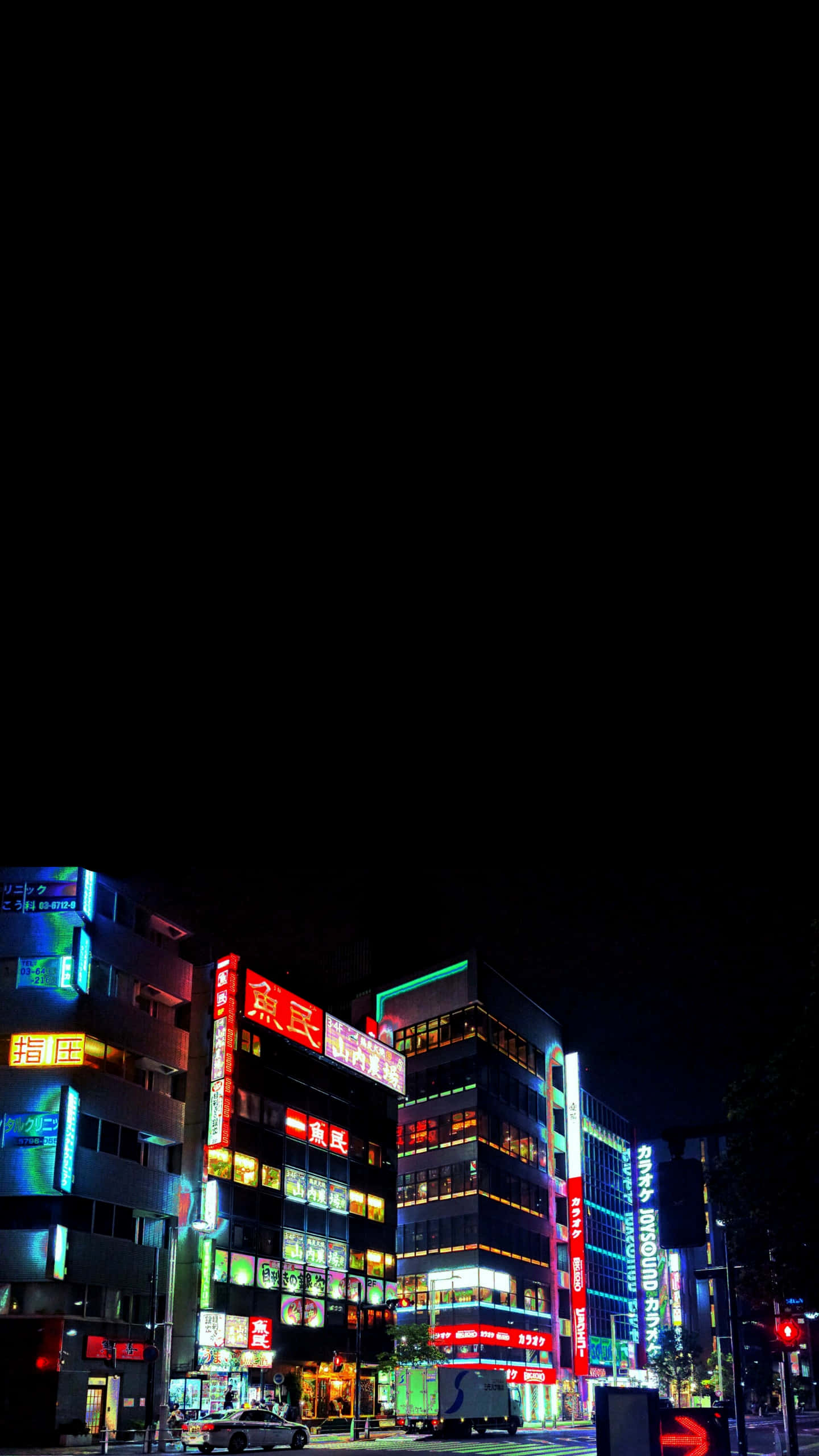 東京 桌布 壁紙 — 鮮豔的霓虹燈照亮了夜晚繁忙的日本城市街道，背景是漆黑的天空。