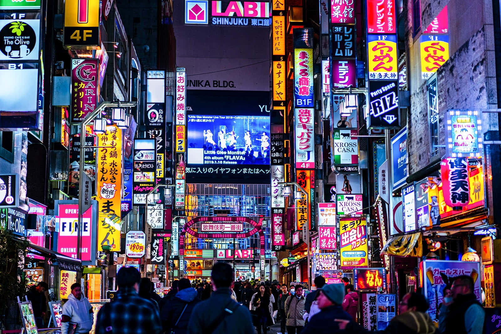 Tokyo Japan 桌布 壁紙 — 鮮豔的霓虹燈照亮了夜晚繁忙的東京街道，人群在發光的廣告牌下行走。
