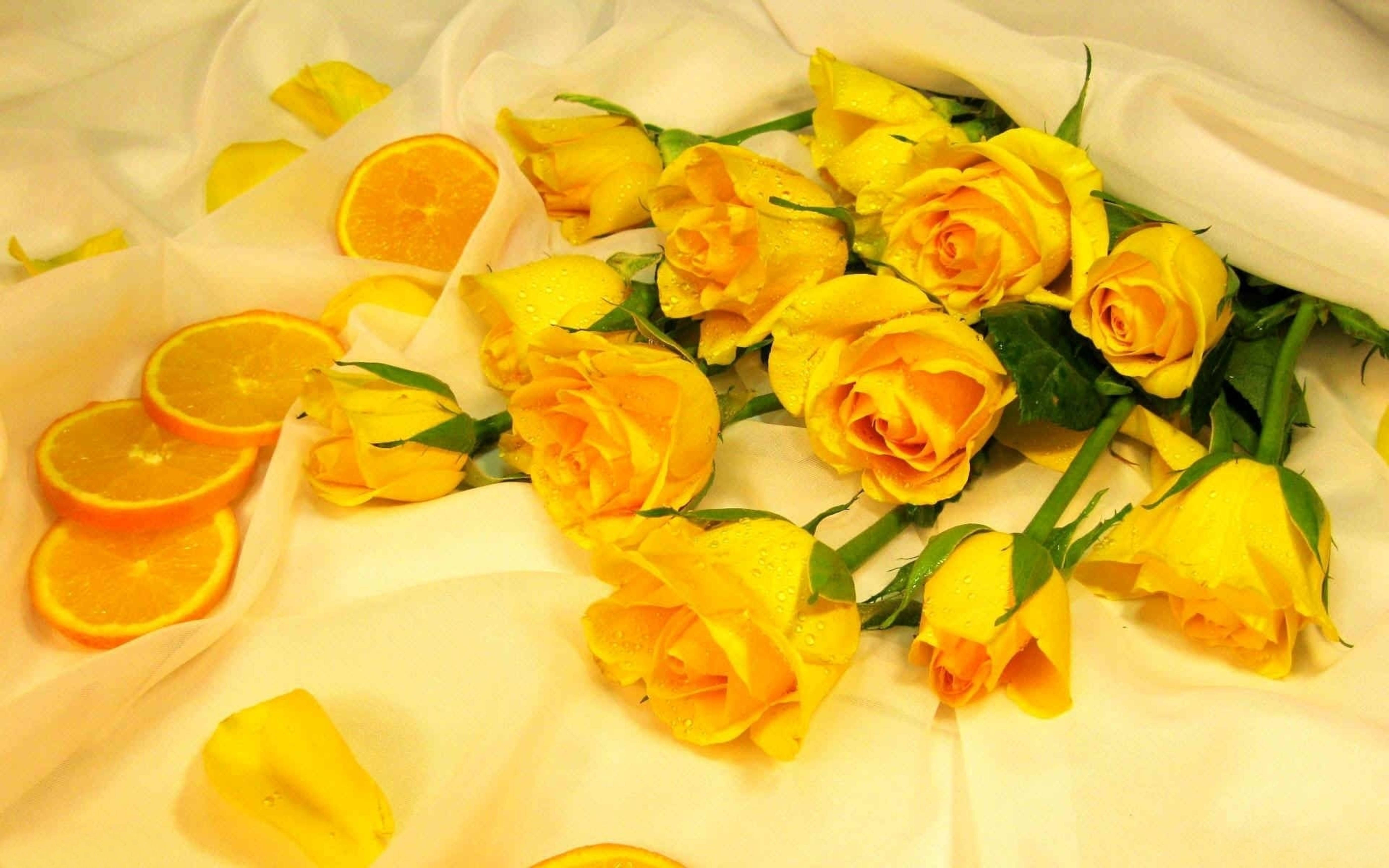 Flowers 桌布 壁紙 — 鮮豔的黃玫瑰和柳橙片放在柔軟的白色布料上，構成溫暖誘人的靜物畫面。
