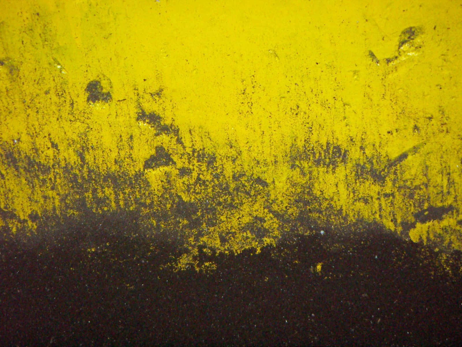 Yellow Grunge 桌布 壁紙 — 鮮豔的黃色油漆在深色表面上剝落和剝離，形成粗糙紋理的抽象構圖。