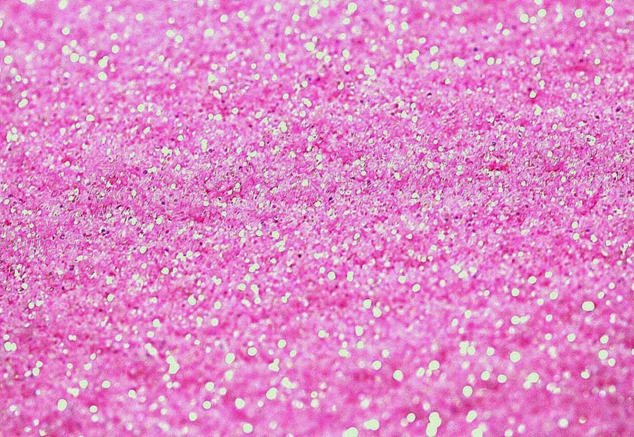 Light Pink Glitter 桌布 壁紙 — 鮮豔粉紅亮粉的特寫，散落白色閃光，營造出閃爍的紋理表面。