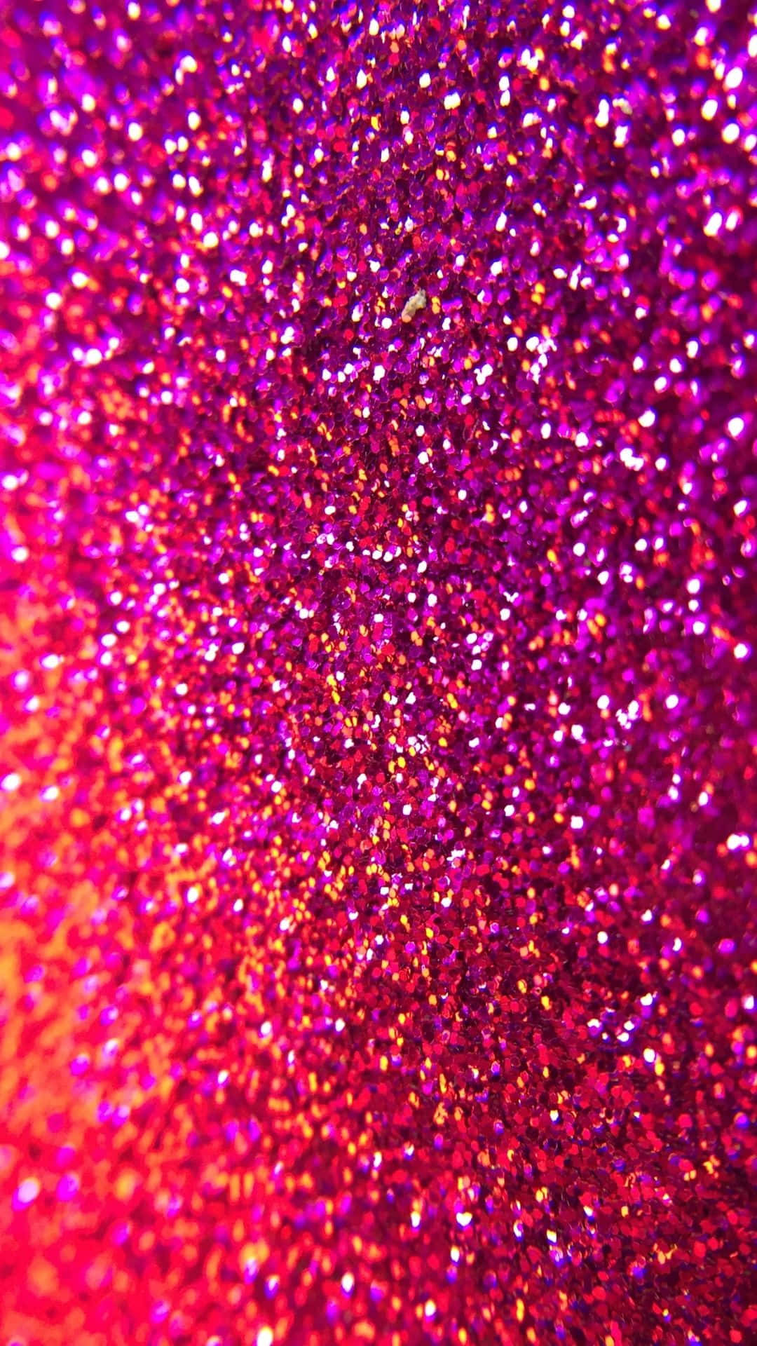 Textured 桌布 壁紙 — 鮮豔粉紅色和紅色閃粉顆粒在明亮光線下閃爍的特寫。