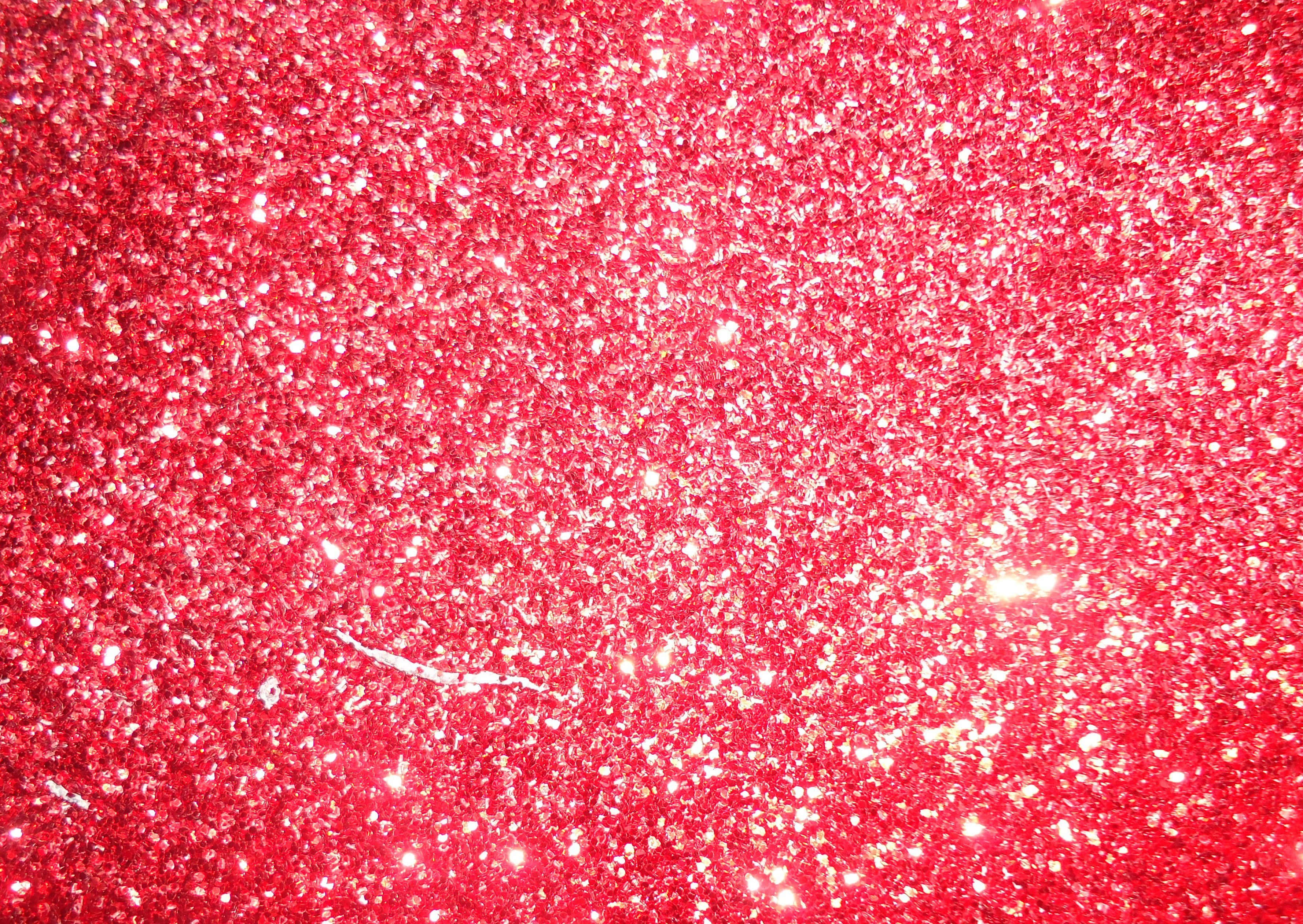 Red Glitter 桌布 壁紙 — 鮮豔紅色亮粉的近距離特寫，帶有捕捉光線的閃亮高光。