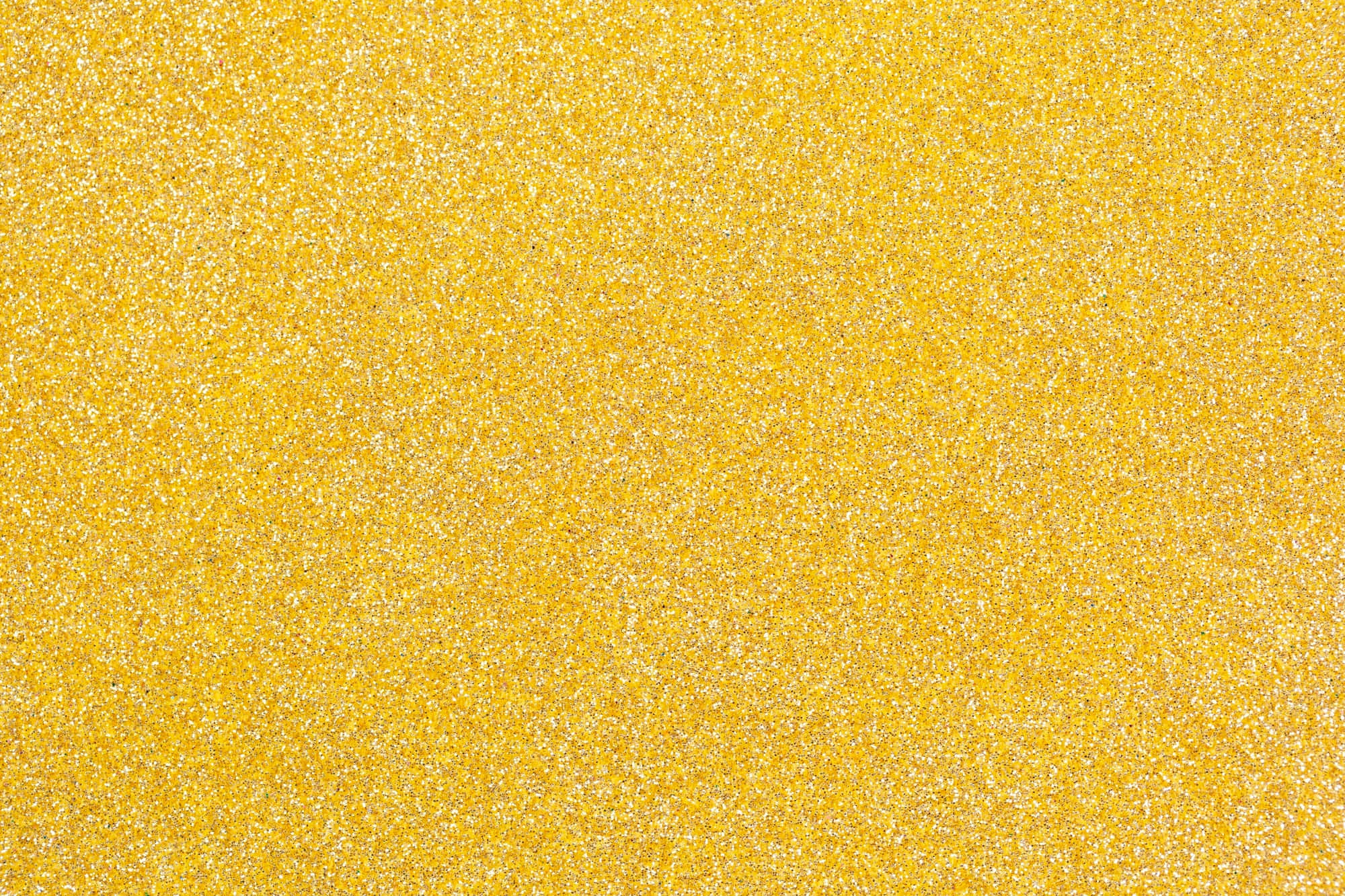 Yellow Glitter 桌布 壁紙 — 鮮黃色亮粉的特寫，散落著銀色閃光，營造出閃爍的紋理表面。