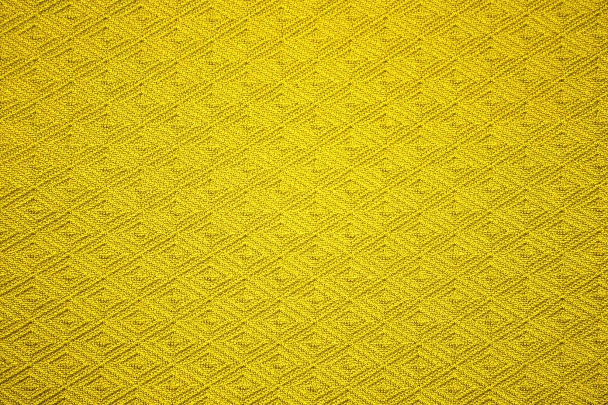 Fabric 桌布 壁紙 — 鮮黃色布料特寫，帶有重複的菱形編織圖案和細微紋理。