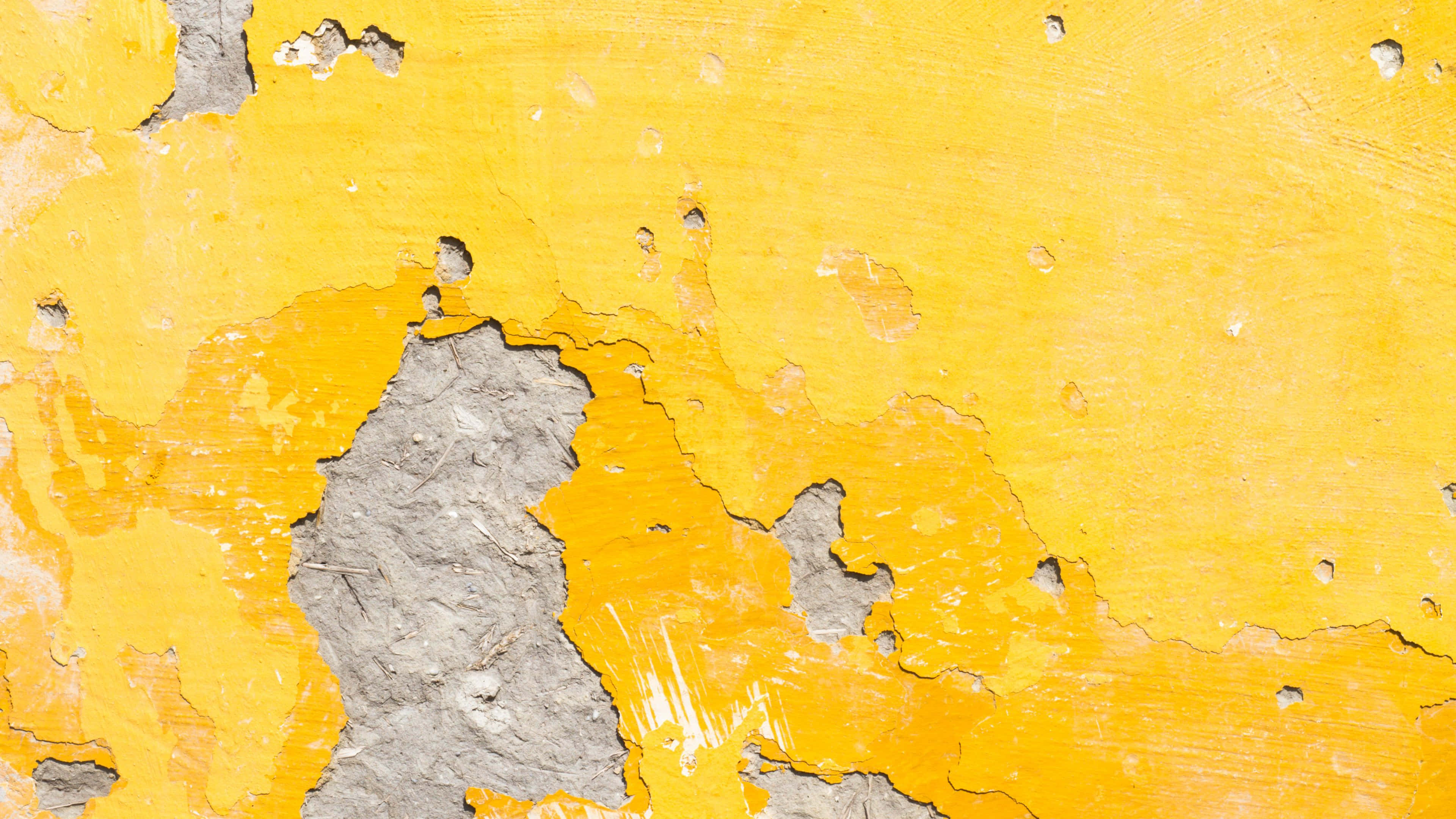 Yellow Grunge 桌布 壁紙 — 鮮黃色油漆從粗糙灰色混凝土上剝落，露出下方有紋理的層次。