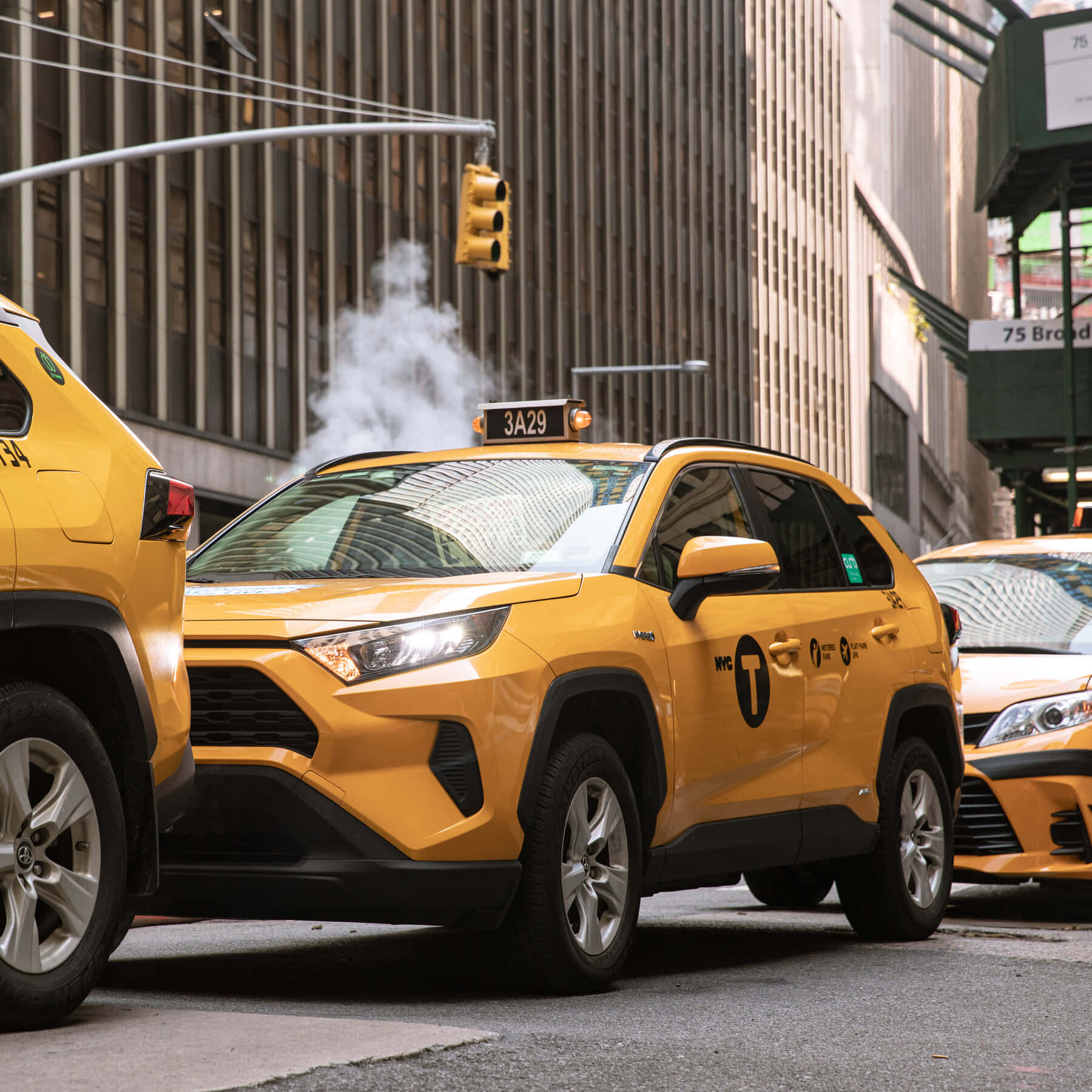 taxi 桌布 壁紙 — 鮮黃色的紐約計程車排列在繁忙的城市街道上，人行道上升起蒸汽，高樓大廈聳立在上方。