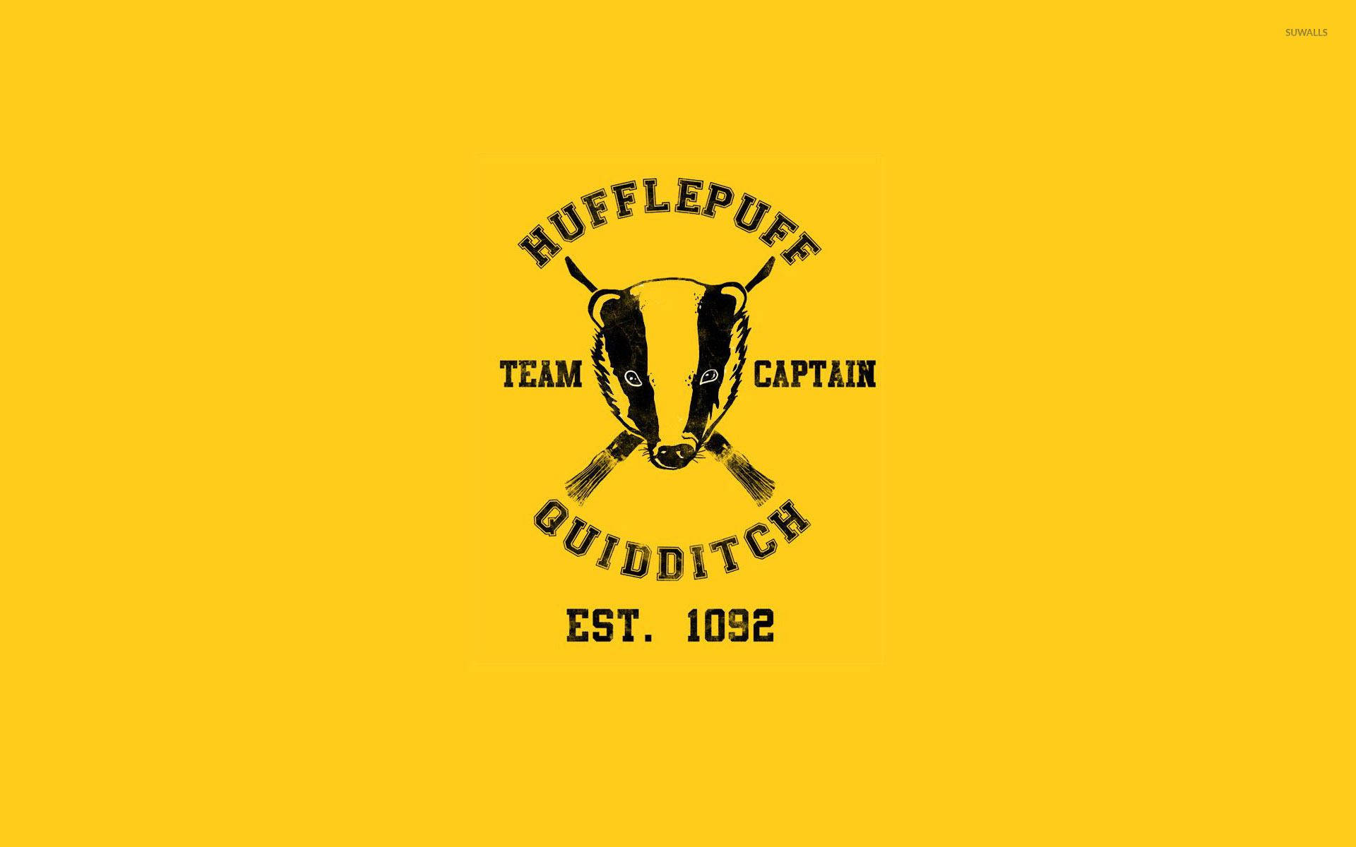 赫夫帕夫 桌布 壁紙 — 鮮黃色背景上，帶有獾吉祥物和交叉掃帚的大膽黑色赫夫帕夫魁地奇球隊標誌。