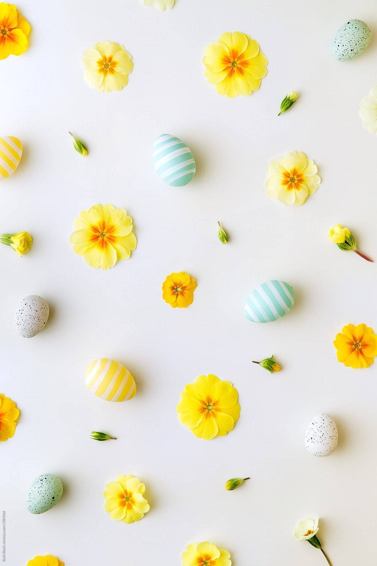 Aesthetic Easter 桌布 壁紙 — 鮮黃色萬壽菊和圖案復活節蛋散落在潔白表面上，構成歡快的春天平鋪佈局。