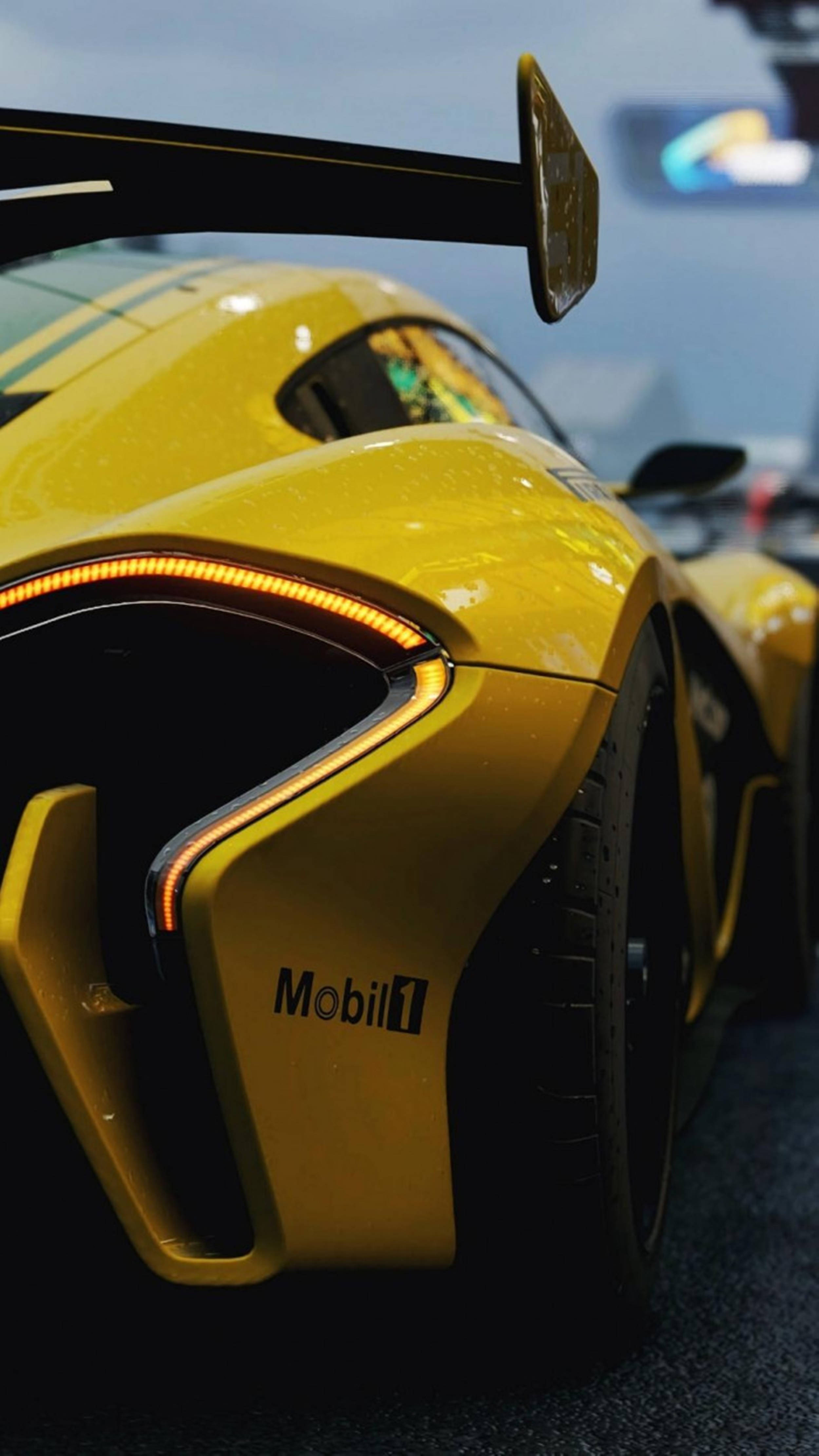 Luxury 桌布 壁紙 — 鮮黃色賽車尾部的特寫，帶有發光的橙色燈光和Mobil 1品牌標識。