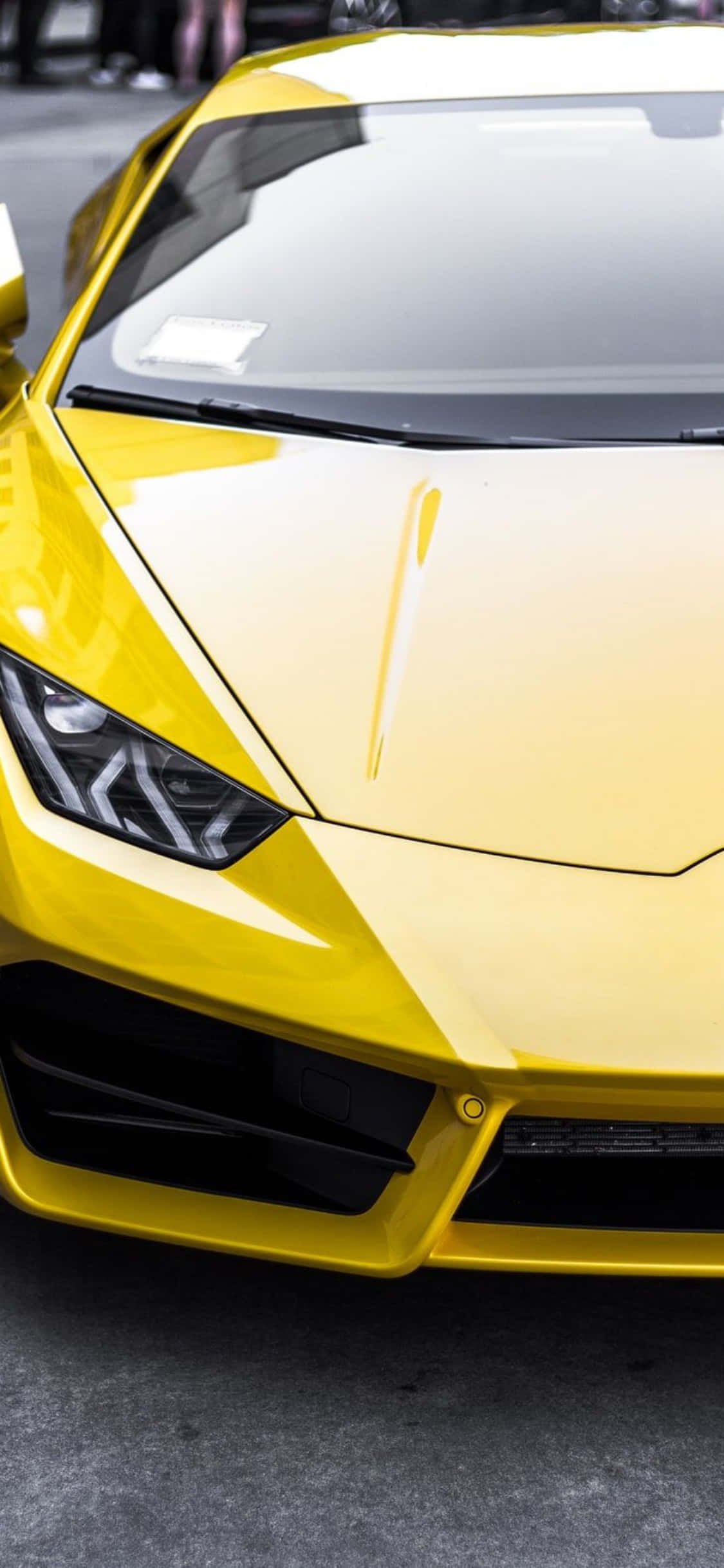 iPhone X Lamborghini 桌布 壁紙 — 鮮黃色跑車具攻擊性的車頭特寫，線條銳利，車燈時尚。