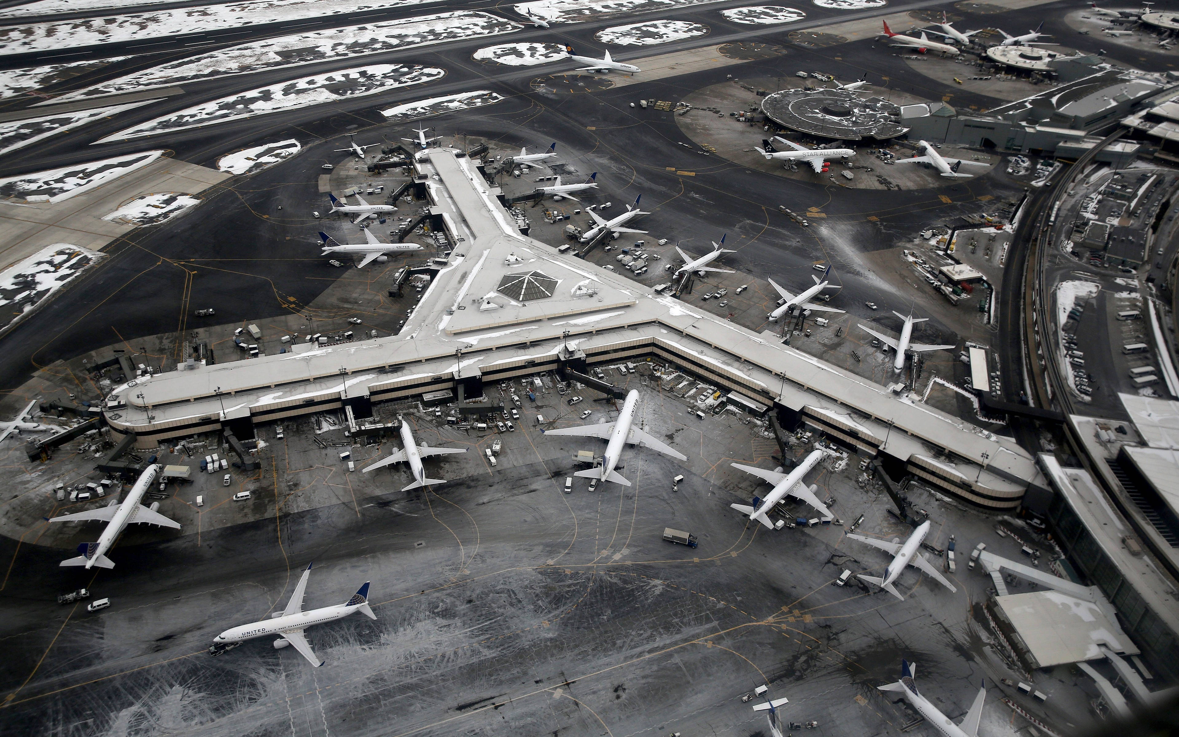 Airport 桌布 壁紙 — 鳥瞰一個被雪覆蓋的機場航廈，大量飛機停泊在登機門和滑行道。