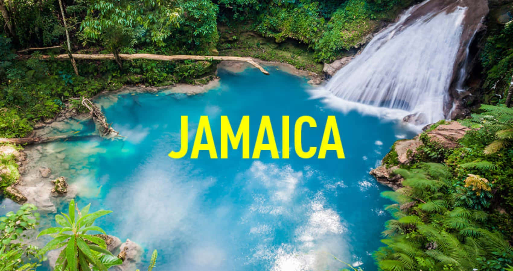 Jamaica 桌布 壁紙 — 鳥瞰圖：一個充滿活力的綠松石瀑布池，周圍環繞著茂密的綠色叢林，並帶有粗體黃色牙買加文字疊加。