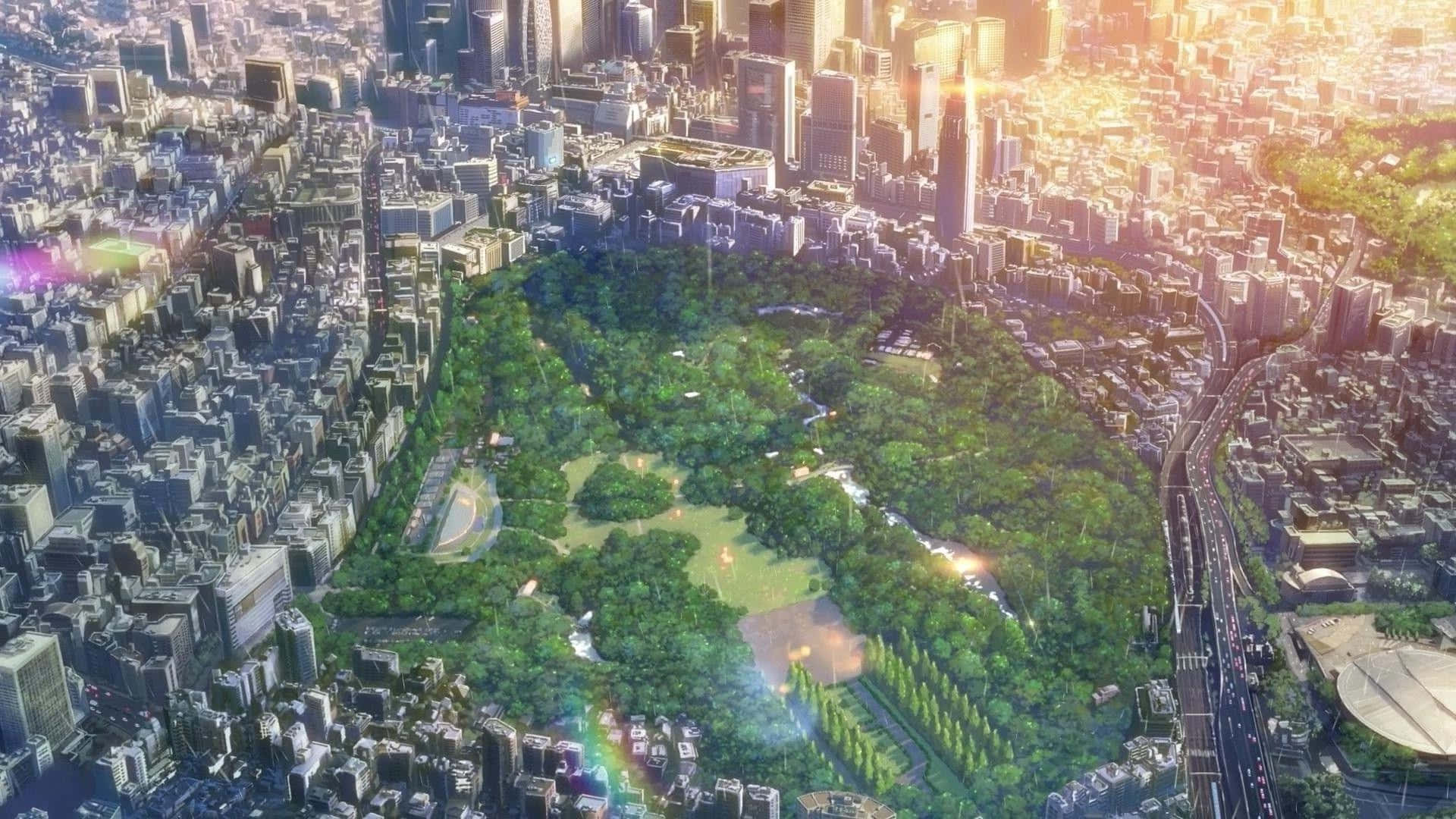 新海誠 桌布 壁紙 — 鳥瞰圖，一片茂密的綠色公園被密集的現代摩天大樓環繞，沐浴在金色的日落光輝中。