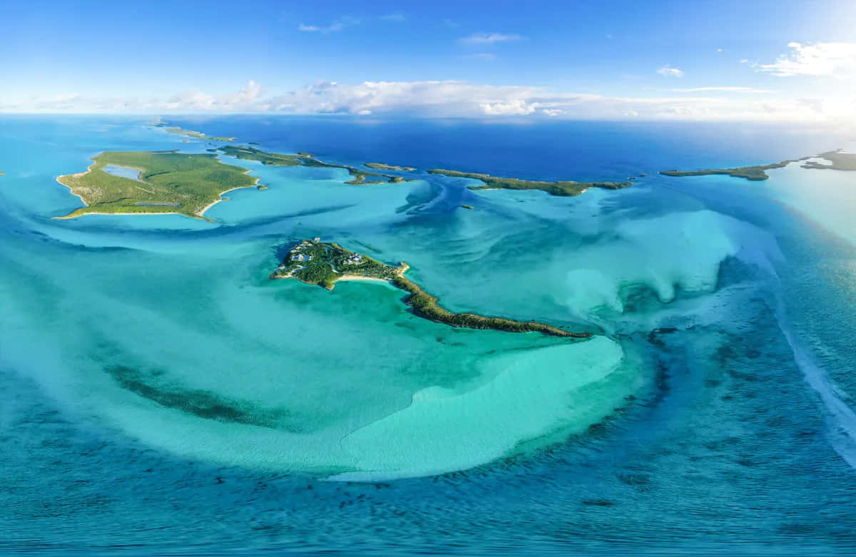 Bahamas Island 桌布 壁紙 — 鳥瞰圖：在明亮藍天與零星白雲下，碧綠潟湖與翠綠島嶼交織。
