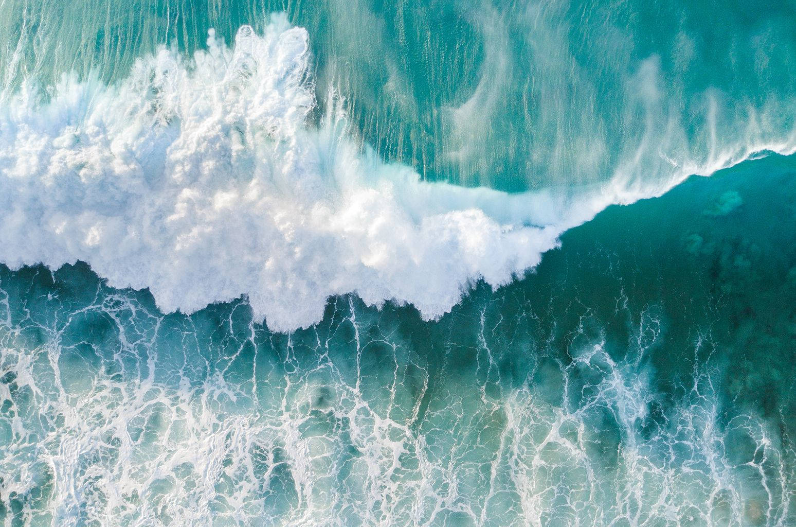 海洋 桌布 壁紙 — 鳥瞰圖：綠松石色的海浪拍打著白色泡沫，與深藍色的海水形成對比。