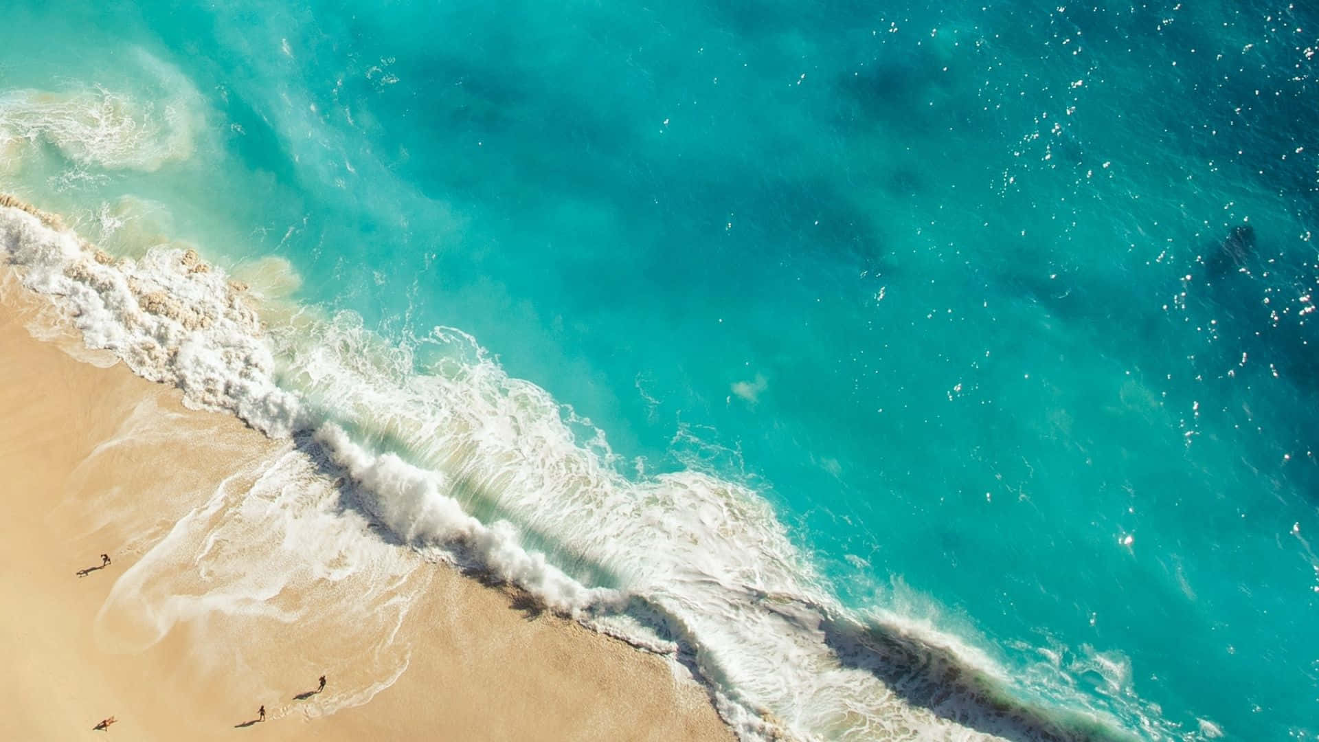 全高清 桌布 壁紙 — 鳥瞰圖：綠松石色的海浪拍打金色沙灘，小小的人影享受著海岸。