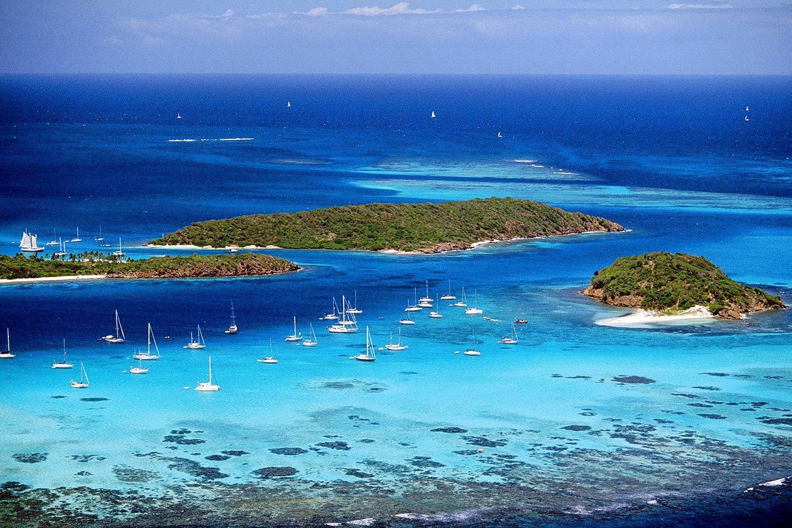 St Vincent And The Grenadines 桌布 壁紙 — 鳥瞰圖：翠綠熱帶島嶼環繞的碧綠潟湖，點綴著帆船