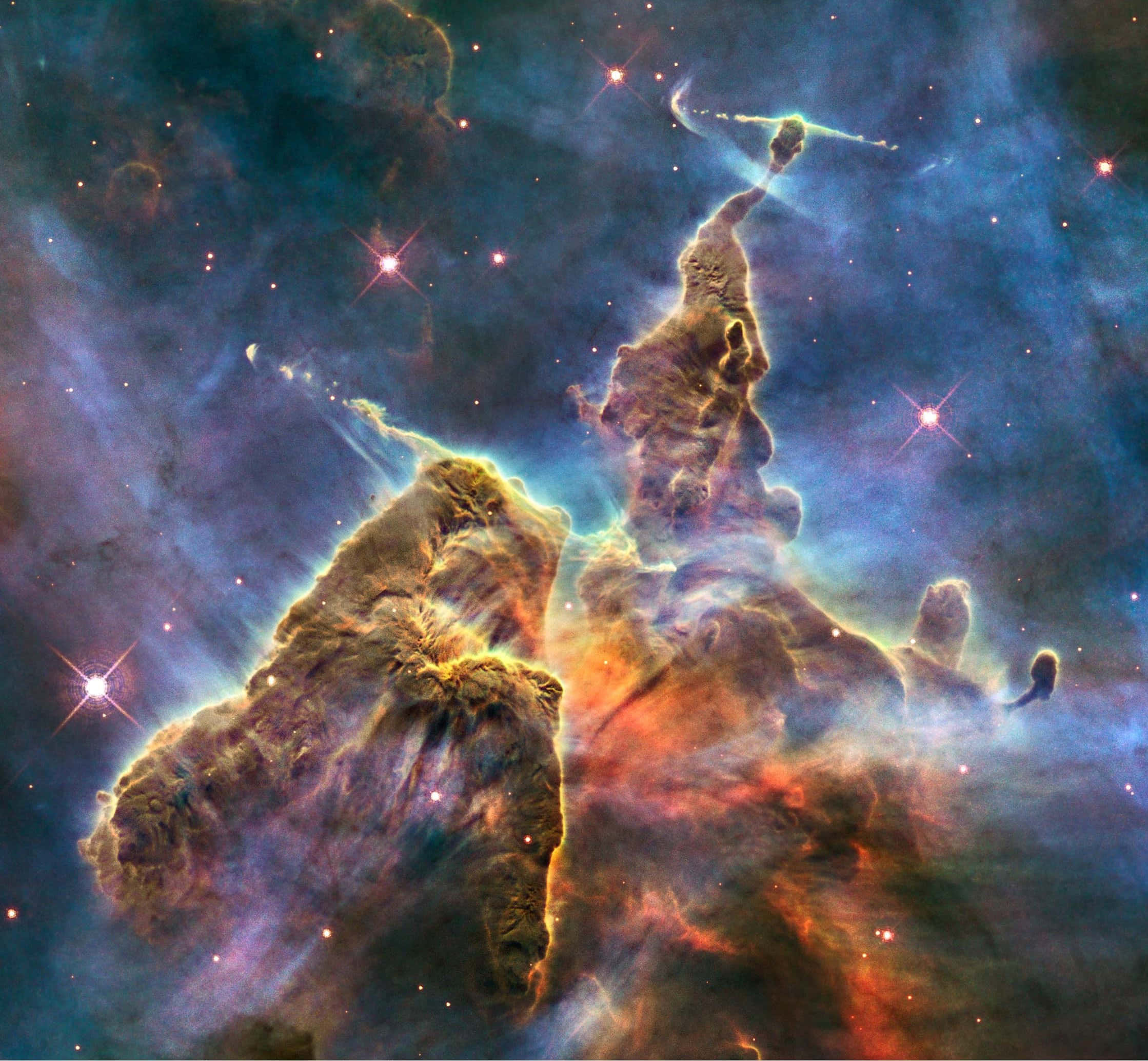 Real Space 桌布 壁紙 — 鷹狀星雲中由氣體和塵埃組成的宇宙柱，在星場背景下散發出火熱的橙色和冷藍色調。
