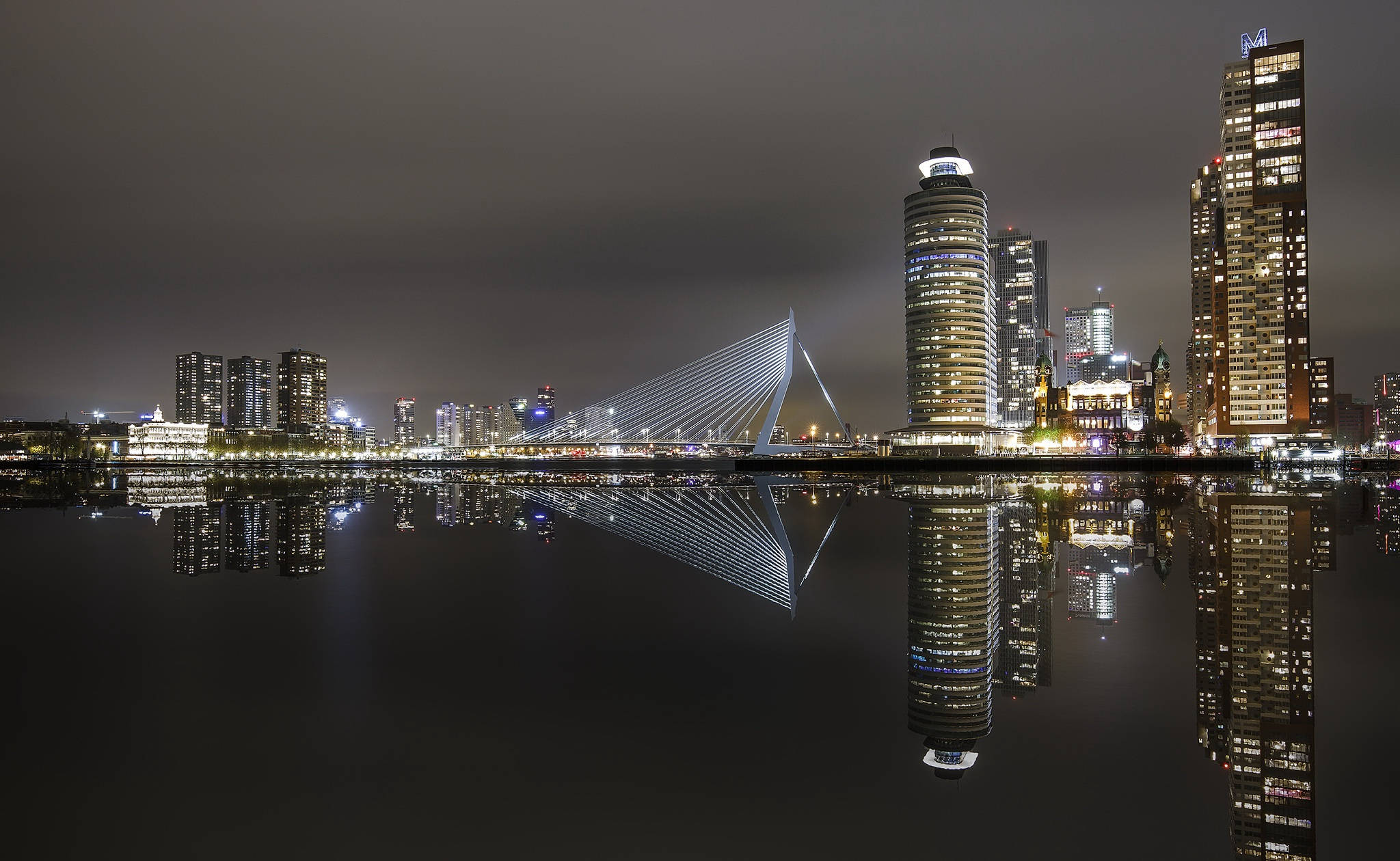 Netherlands 桌布 壁紙 — 鹿特丹令人驚嘆的夜景，伊拉斯謨斯橋和摩天大樓完美倒映在平靜的水面上。